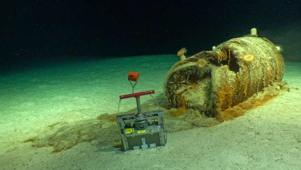 Fût de déchets radioactifs présentant une dégradation importante, déversement de matières sur les fonds marins environnants et dispositif d'échantillonnage des sédiments déployé puis récupéré par le Nautile sur le site de stockage de déchets...
