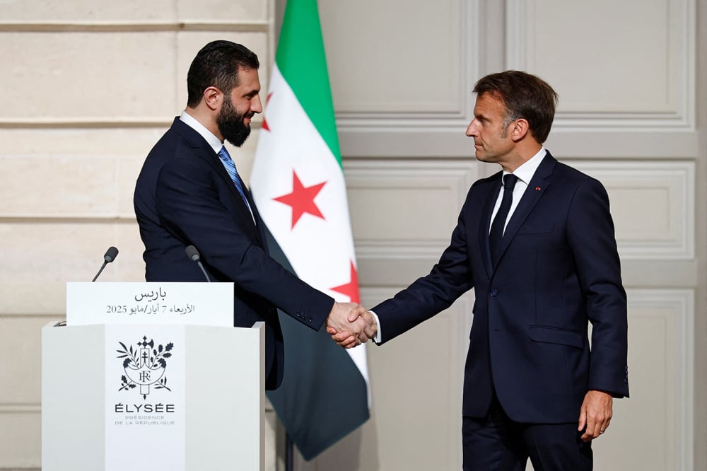 Le président français Emmanuel Macron serre la main du président syrien par intérim Ahmed al-Charaa après une conférence de presse conjointe à l'issue de leur rencontre au palais de l'Élysée, à Paris, le 7 mai 2025.