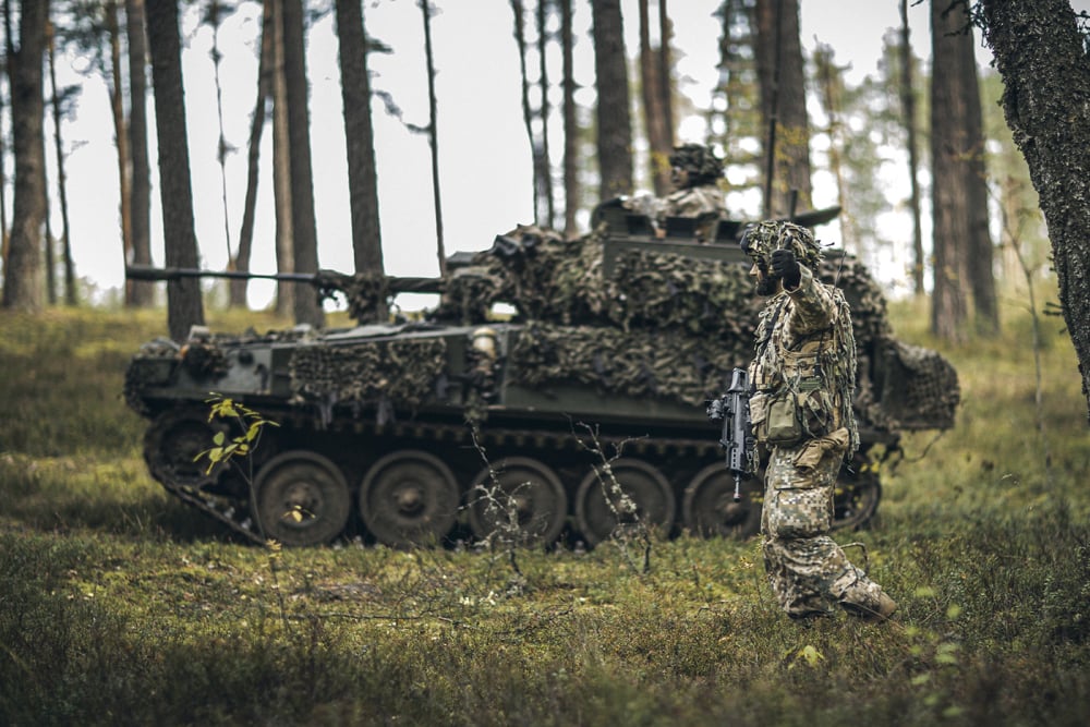 Des soldats d'infanterie des forces armées nationales lettones, appuyés par des véhicules blindés lettons CVRT Scimitar, participent à un exercice de l'OTAN.
