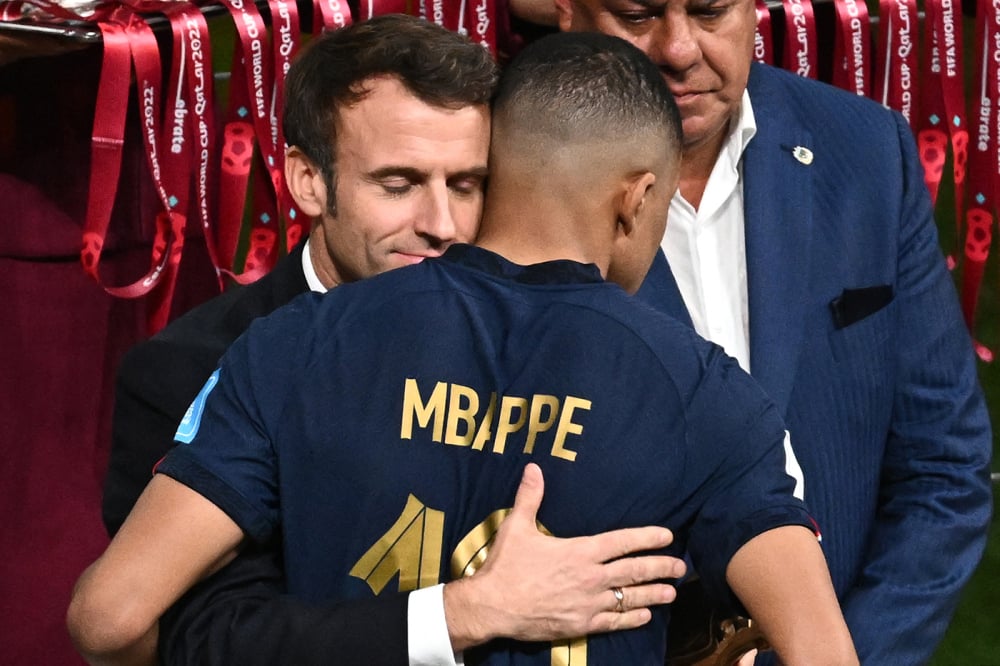 Emmanuel Macron enlace Kylian Mbappé à l'issue de la finale de la Coupe du monde 2022 entre l'Argentine et la France, au Qatar, le 18 décembre 2022.