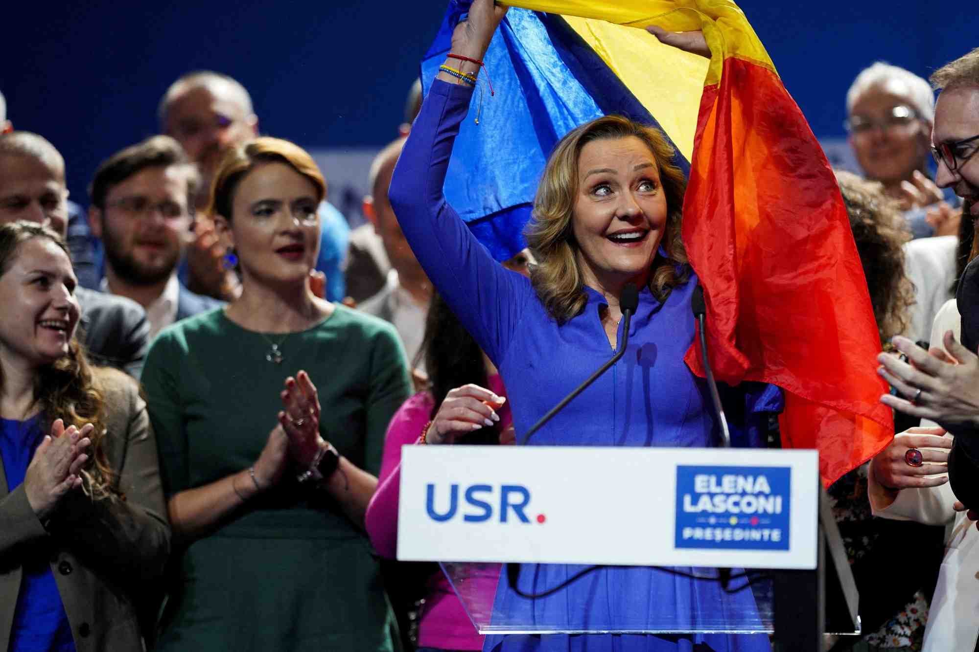 La dirigeante du parti d'opposition de centre-droit union sauvez la roumanie (usr), elena lasconi, passe sous un drapeau roumain apres son discours, alors qu'elle est entree au second tour de l'election presidentielle, a bucarest