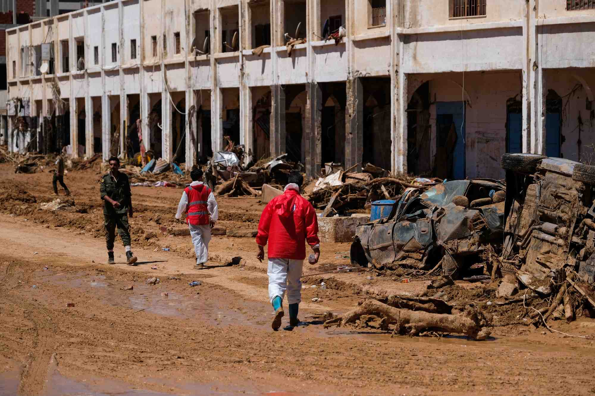 Des membres du croissant rouge marchent parmi des decombres a derna en libye