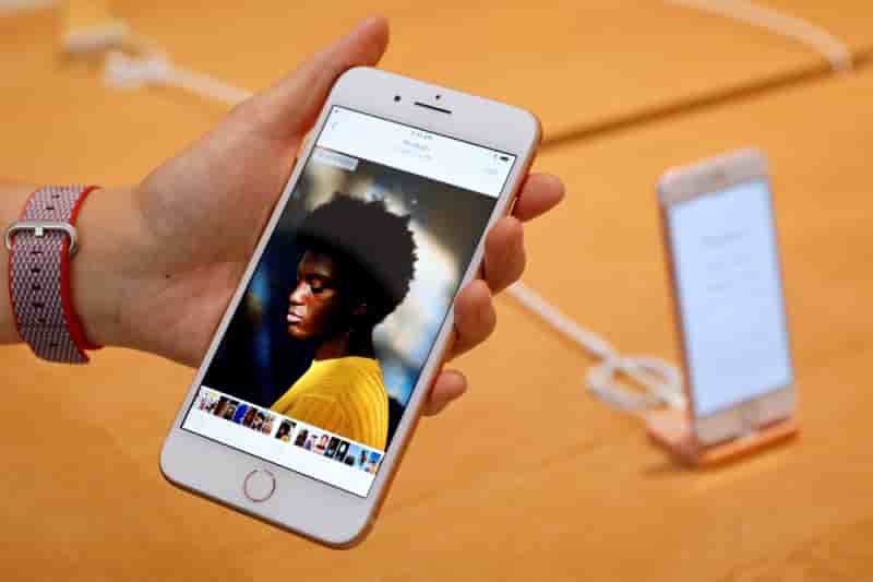 Un employe d'apple presente un iphone 8 plus dans une boutique du groupe a singapour