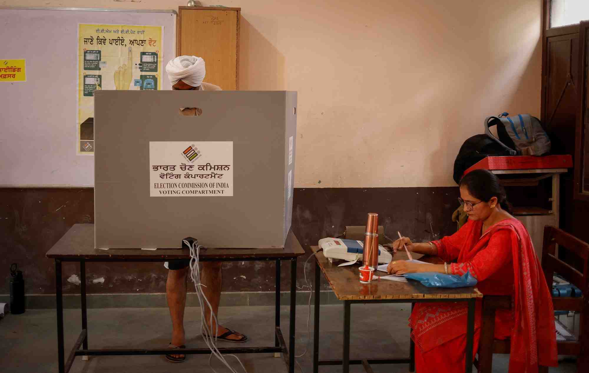Des personnes dans un bureau de vote lors de la septieme et derniere phase des elections generales, dans le district de faridkot