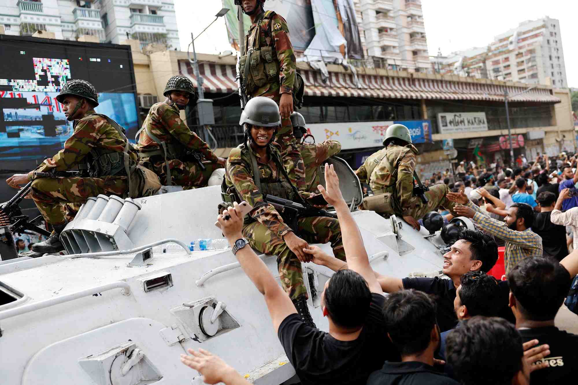 Des gens a dhaka serrent la main du personnel de l'armee alors qu'ils celebrent la demission de la premiere ministre bangladaise sheikh hasina