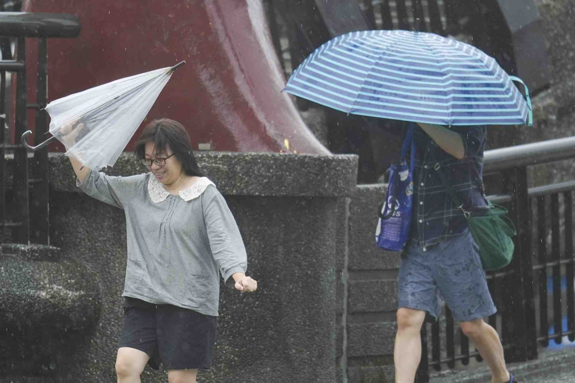 Des personnes tiennent des parapluies alors que le typhon kong-rey approche a keelung