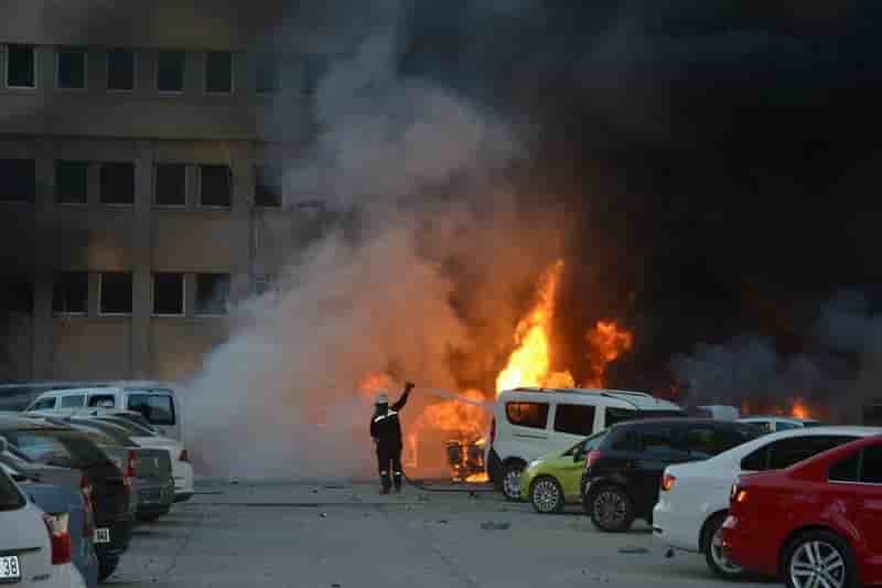 A firefighter tries to extinguish burning vehicles after an explosion outside the governor's office in the southern city of adana