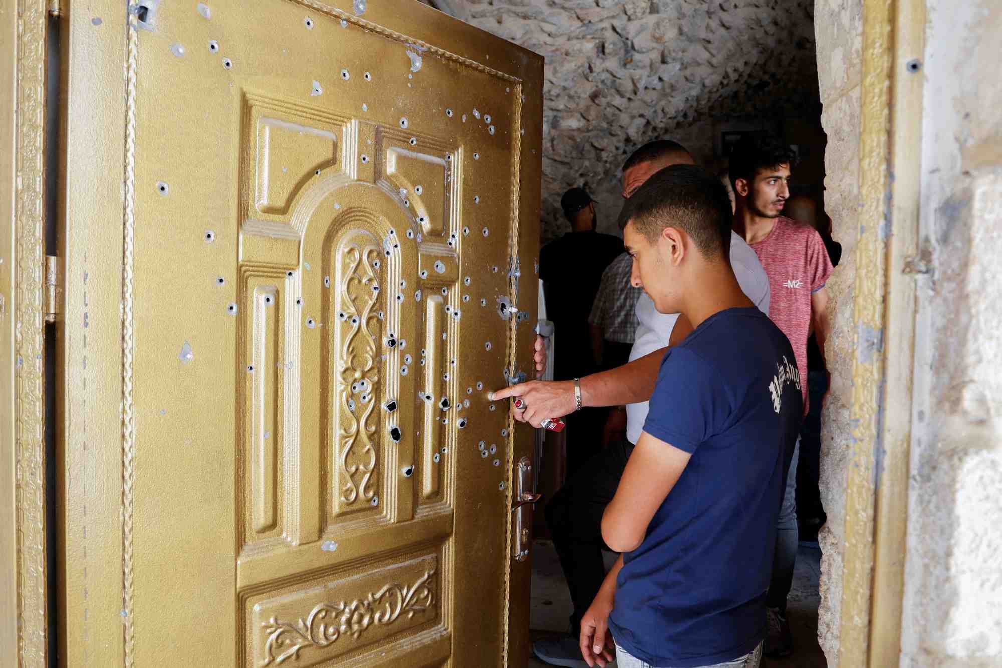 Les gens verifient les degats dans une maison ou deux palestiniens a naplouse