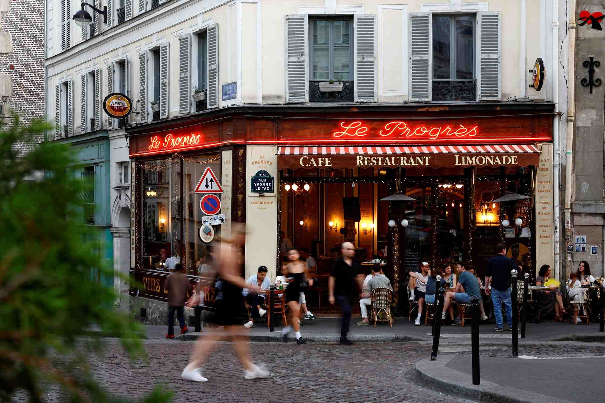 Des gens passent devant un restaurant a paris