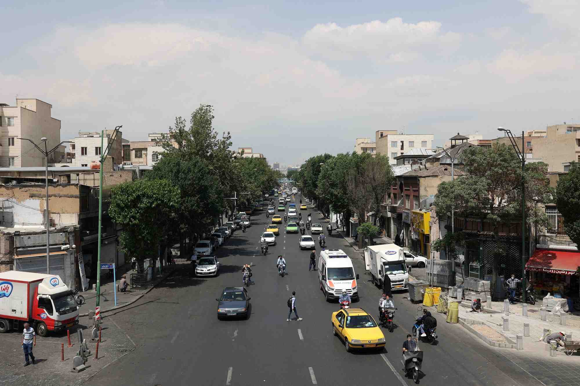 Des voitures roulent dans une rue de teheran