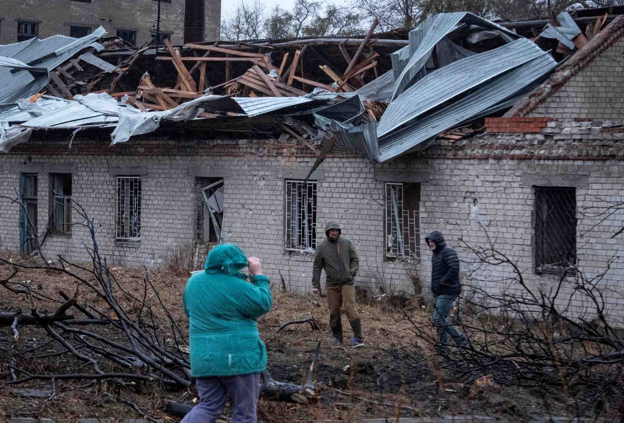 Des residents marchent sur le site d'une frappe de missile russe a dnipro
