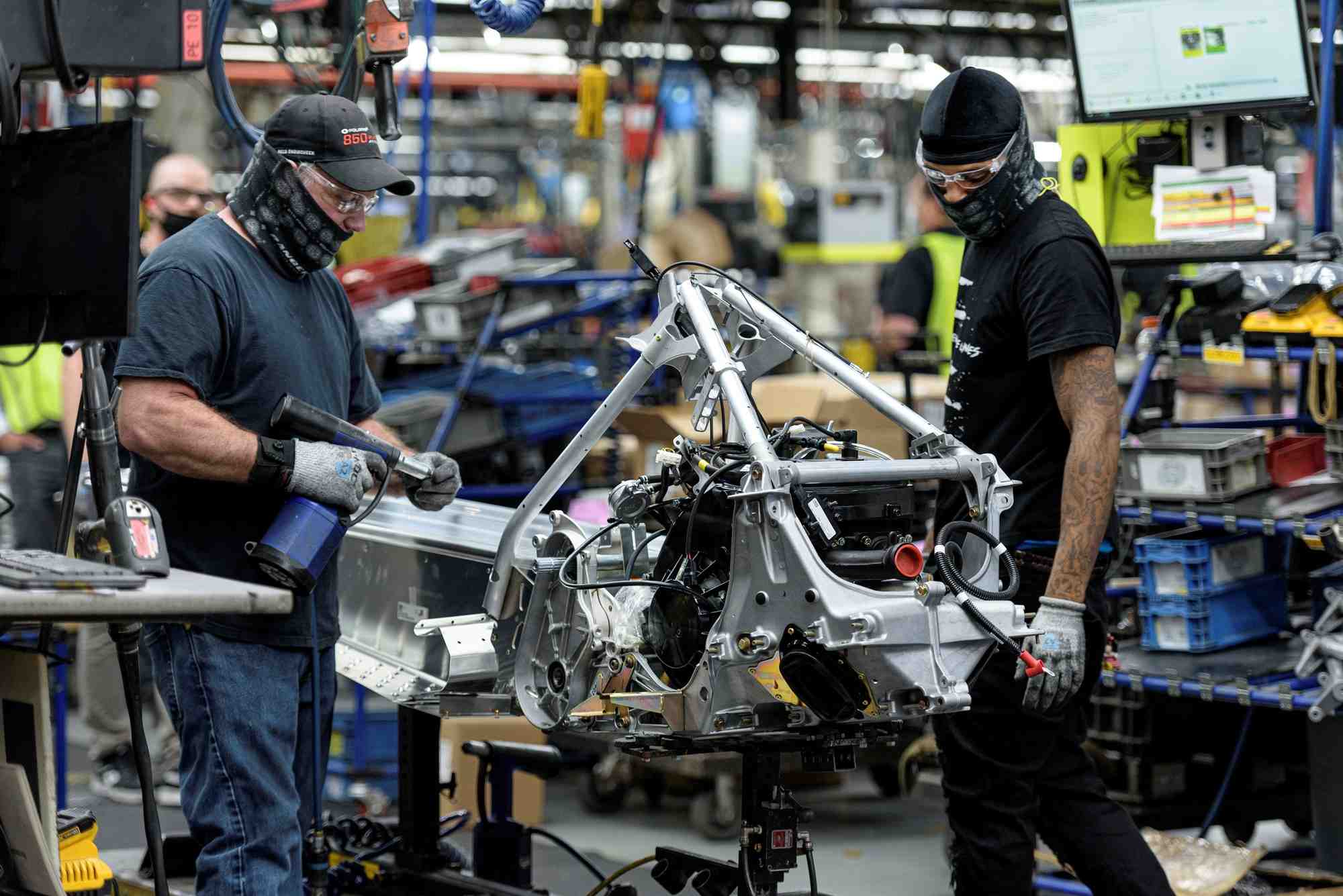 Des employes sur une chaine de montage de motoneiges polaris dans une usine de fabrication et d'assemblage a roseau