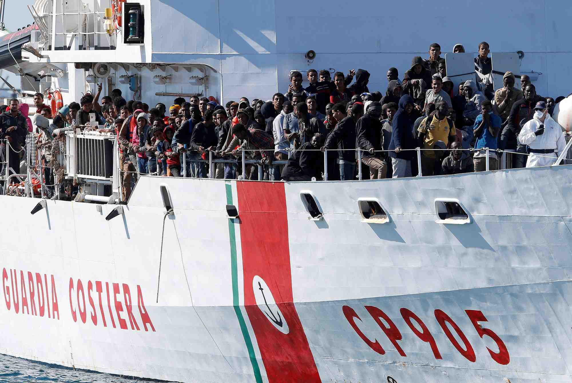 Des migrants arrivent par le peluso, navire des garde-cotes italiens, dans le port sicilien d'augusta