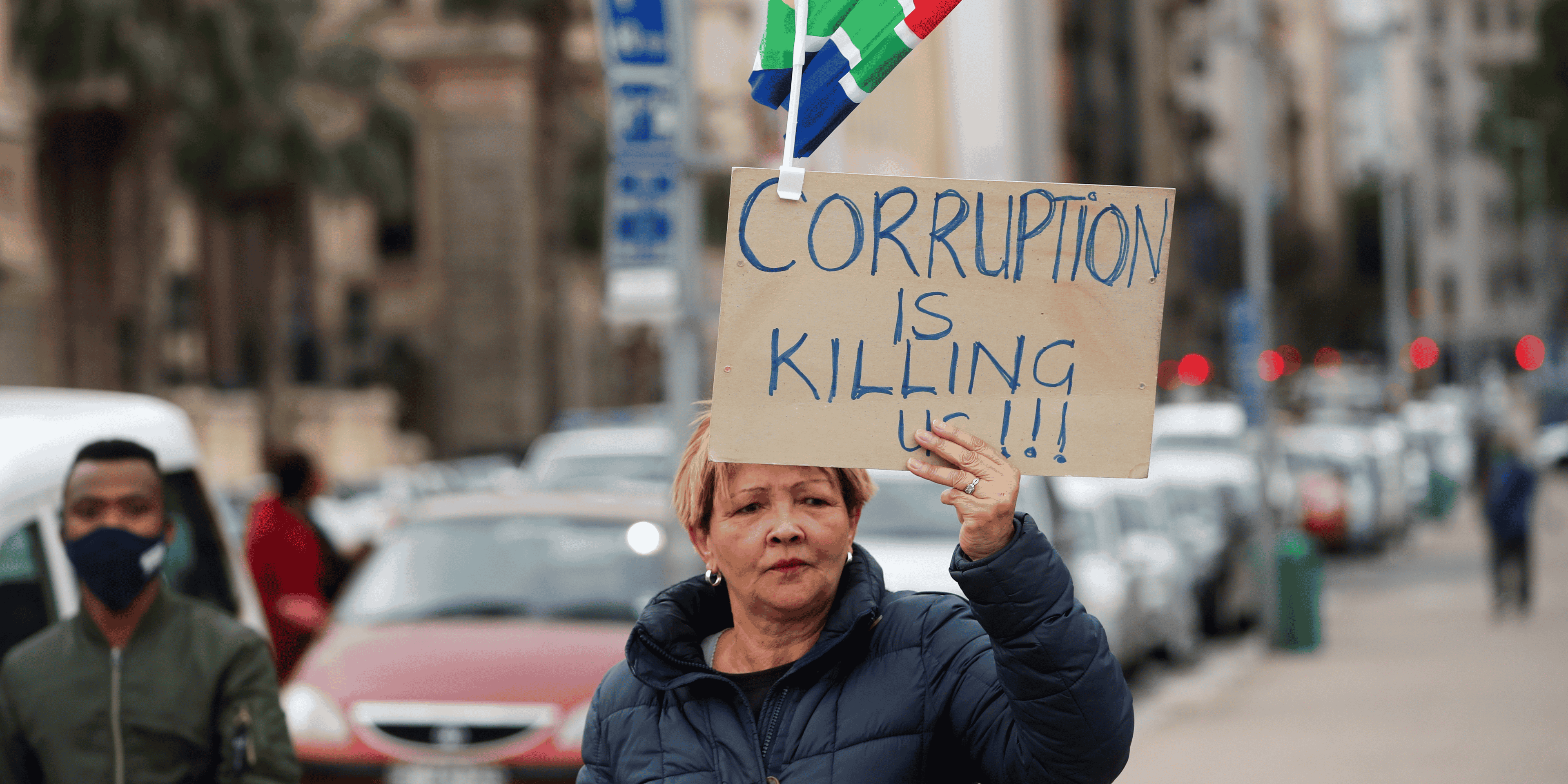Afrique du Sud : une manifestante tient une pancarte disant "La corruption tue" à Cape Town le 5 septembre 2020