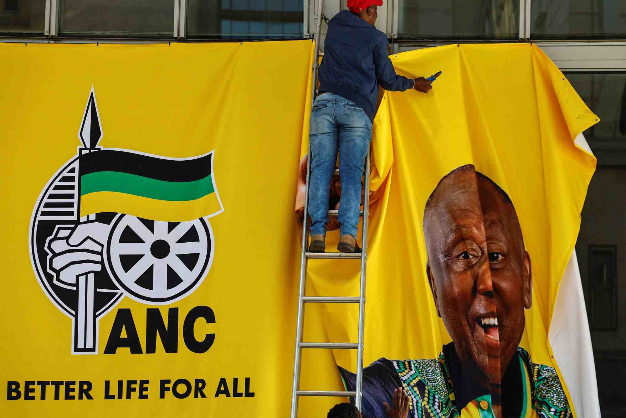 Un ouvrier enleve une banniere de campagne apres une manifestation du congres national africain (anc)