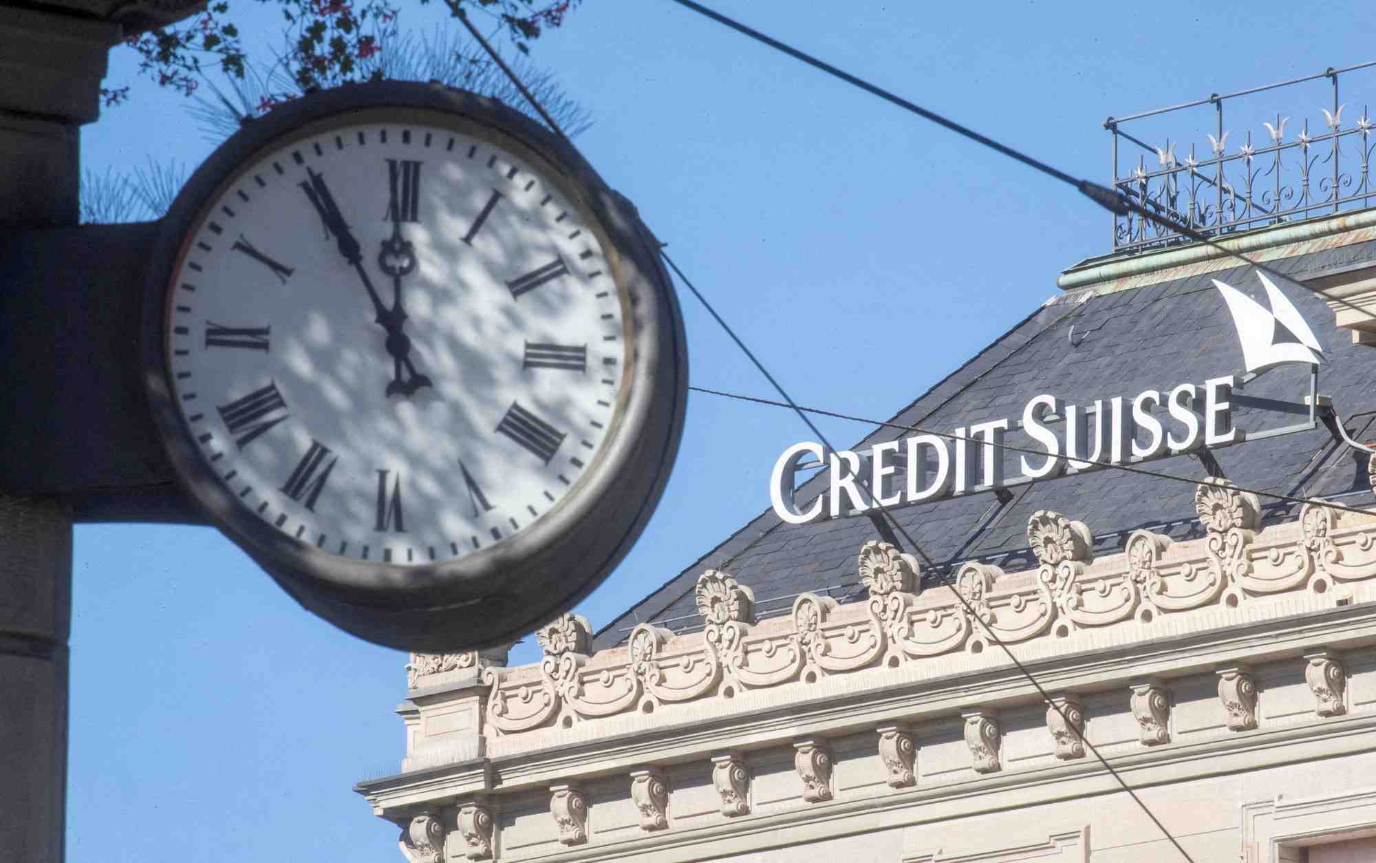 Une horloge pres du logo de la banque credit suisse sur la place paradeplatz a zurich, suisse