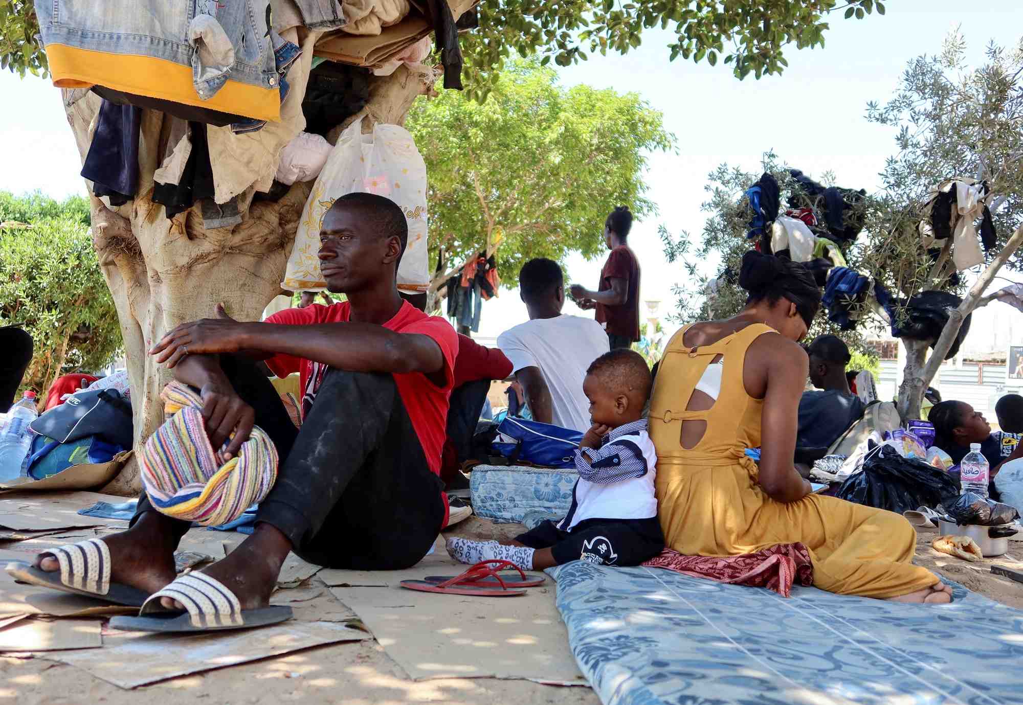 Un migrant guineen assis avec d'autres migrants dans un jardin public a sfax, en tunisie