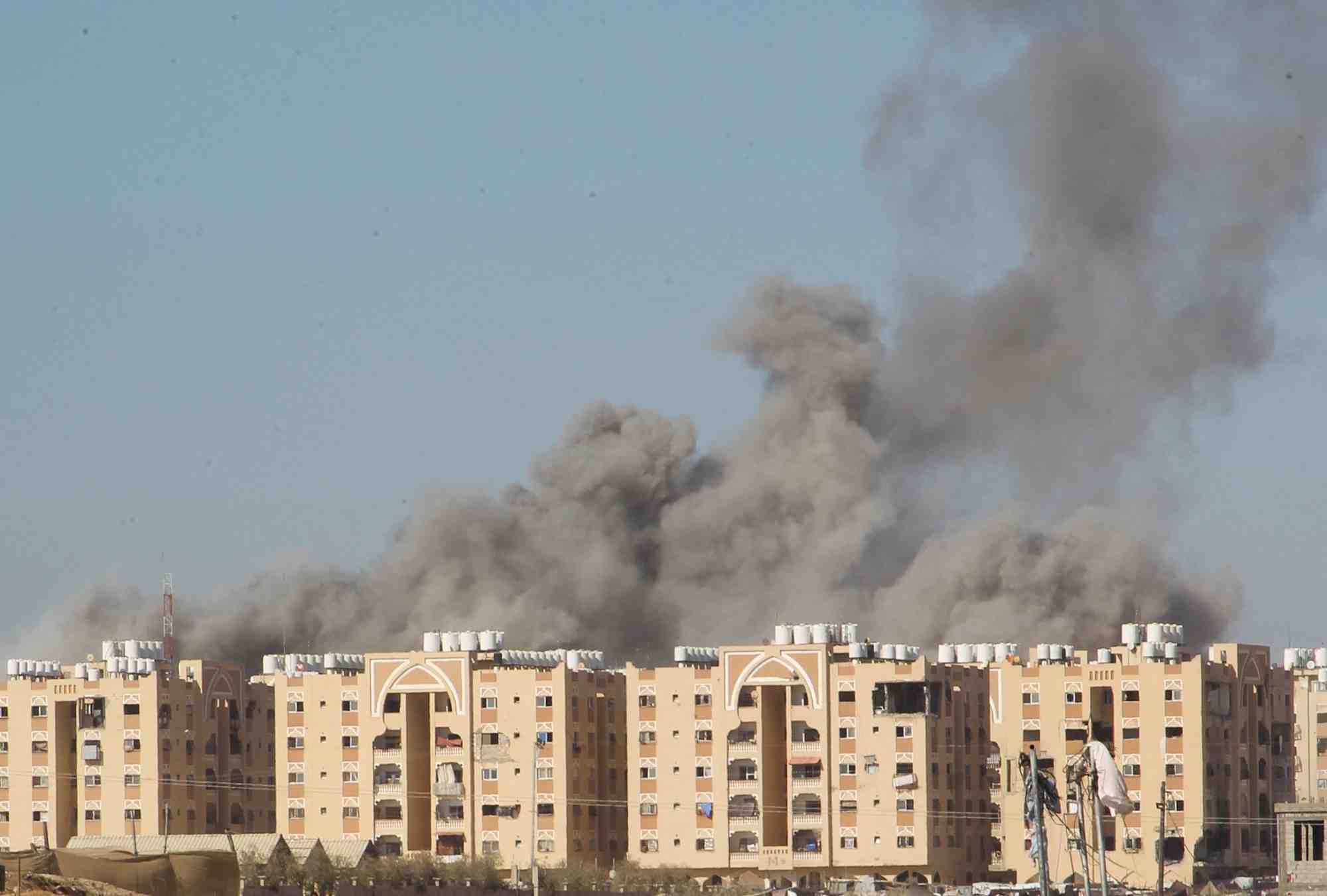 De la fumee s'eleve au-dessus d'immeubles residentiels dans la bande de gaza