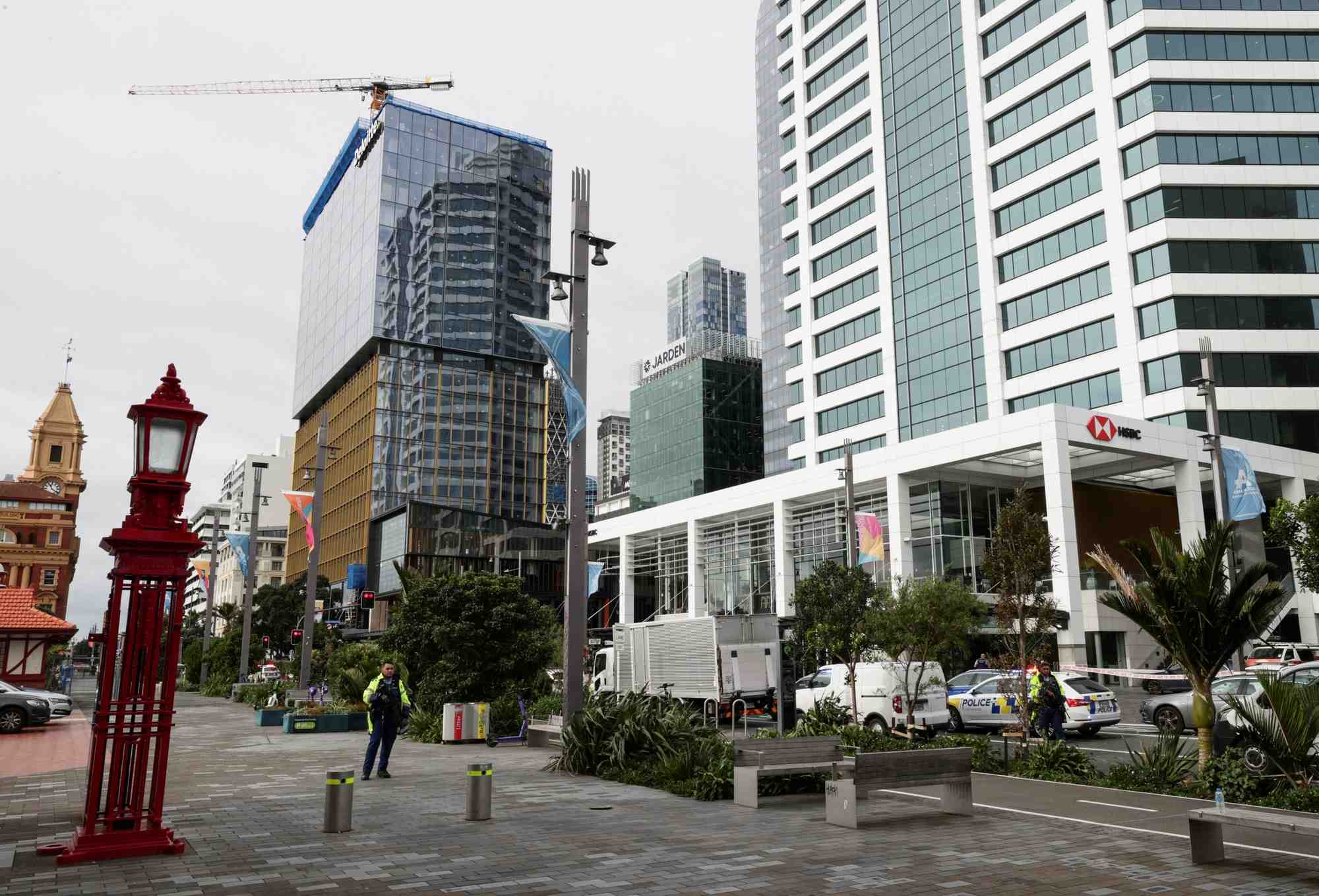 Des policiers armes montent la garde pres d'un chantier de construction apres une fusillade a auckland