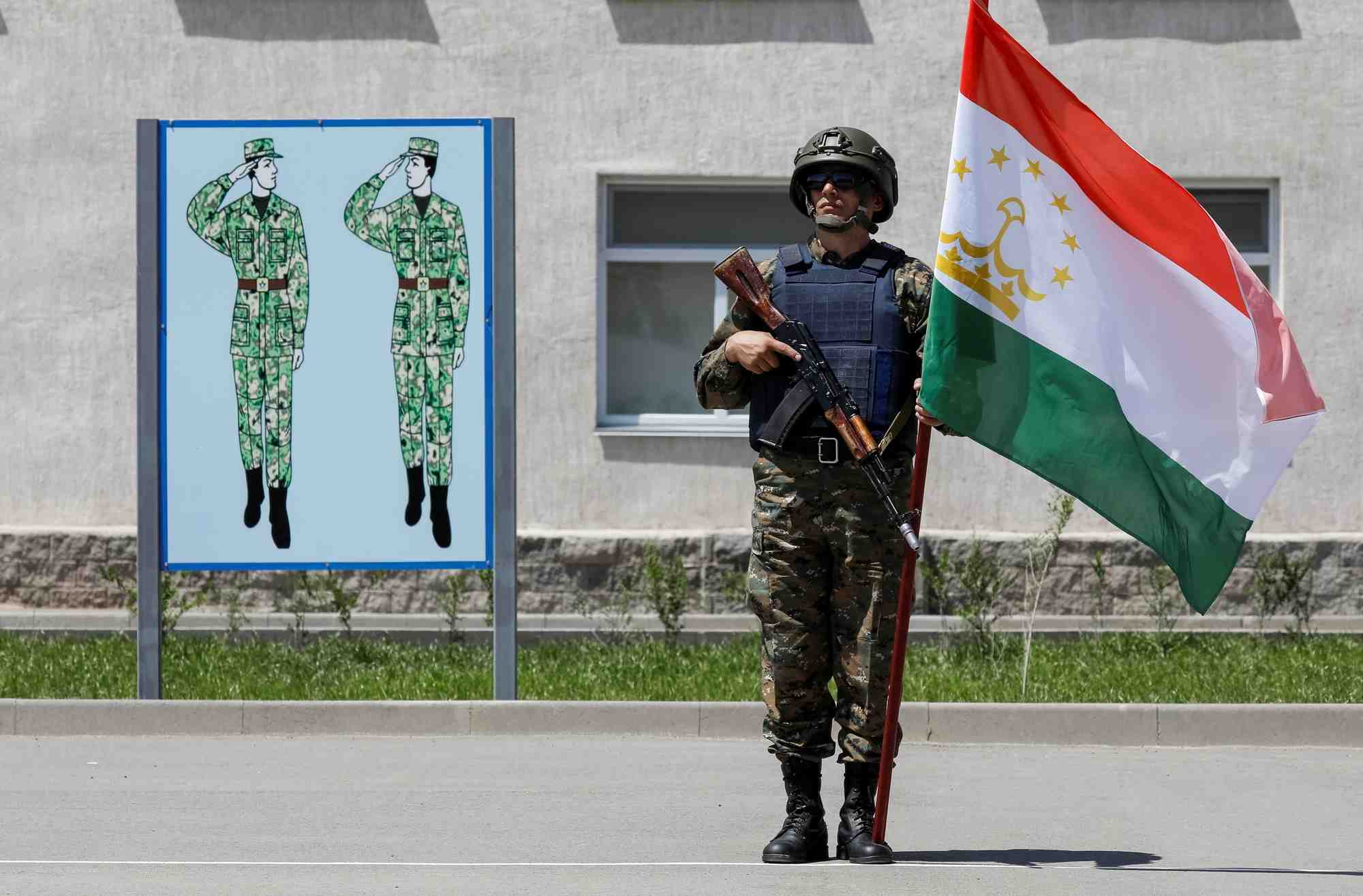 Photo d'archives d'un soldat tenant un drapeau du tadjikistan lors d'exercices militaires pres d'almaty, au kazakhstan