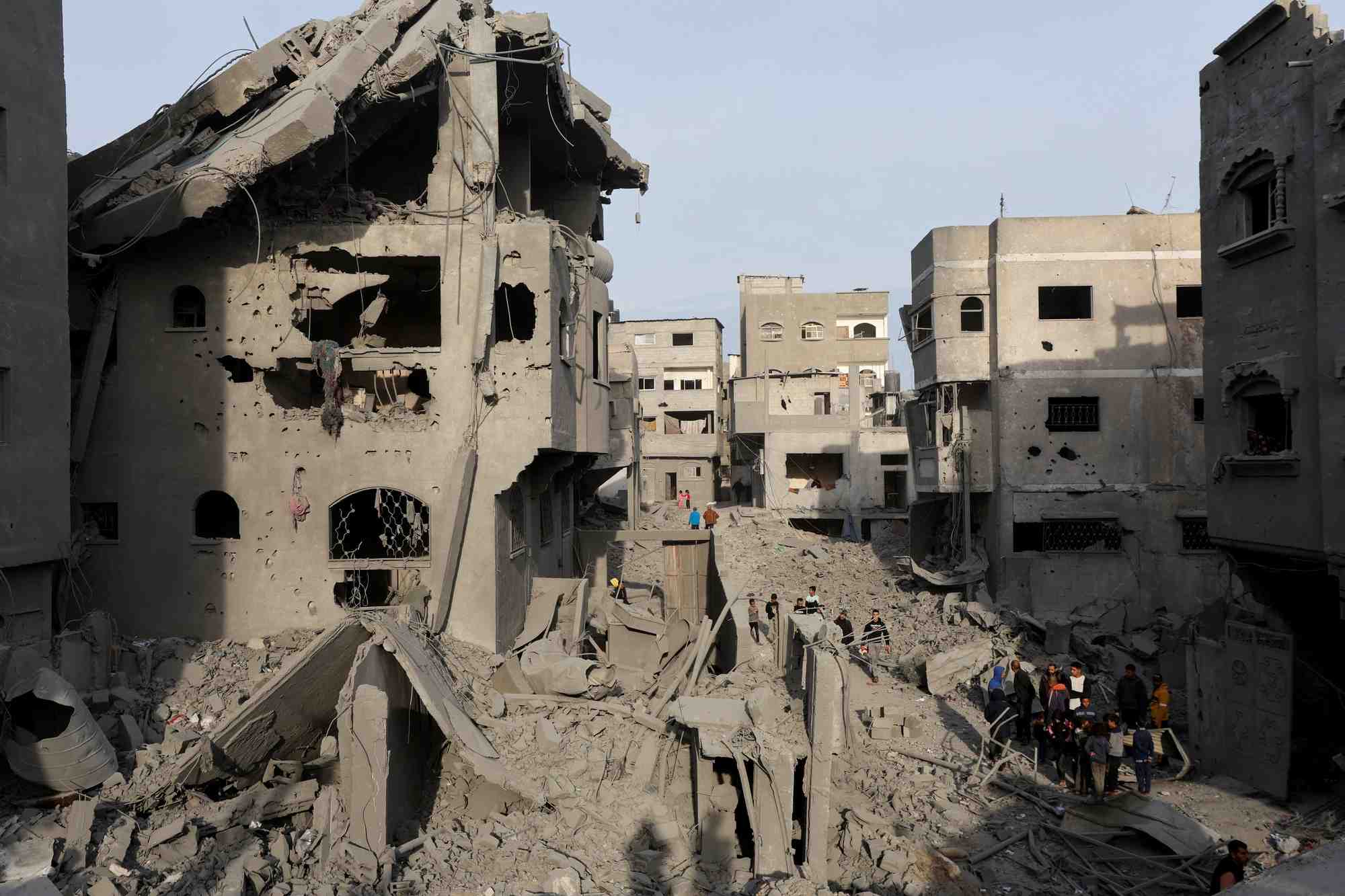 Des palestiniens inspectent les degats sur le site d'une frappe israelienne sur une maison, dans le camp de refugies de nuseirat
