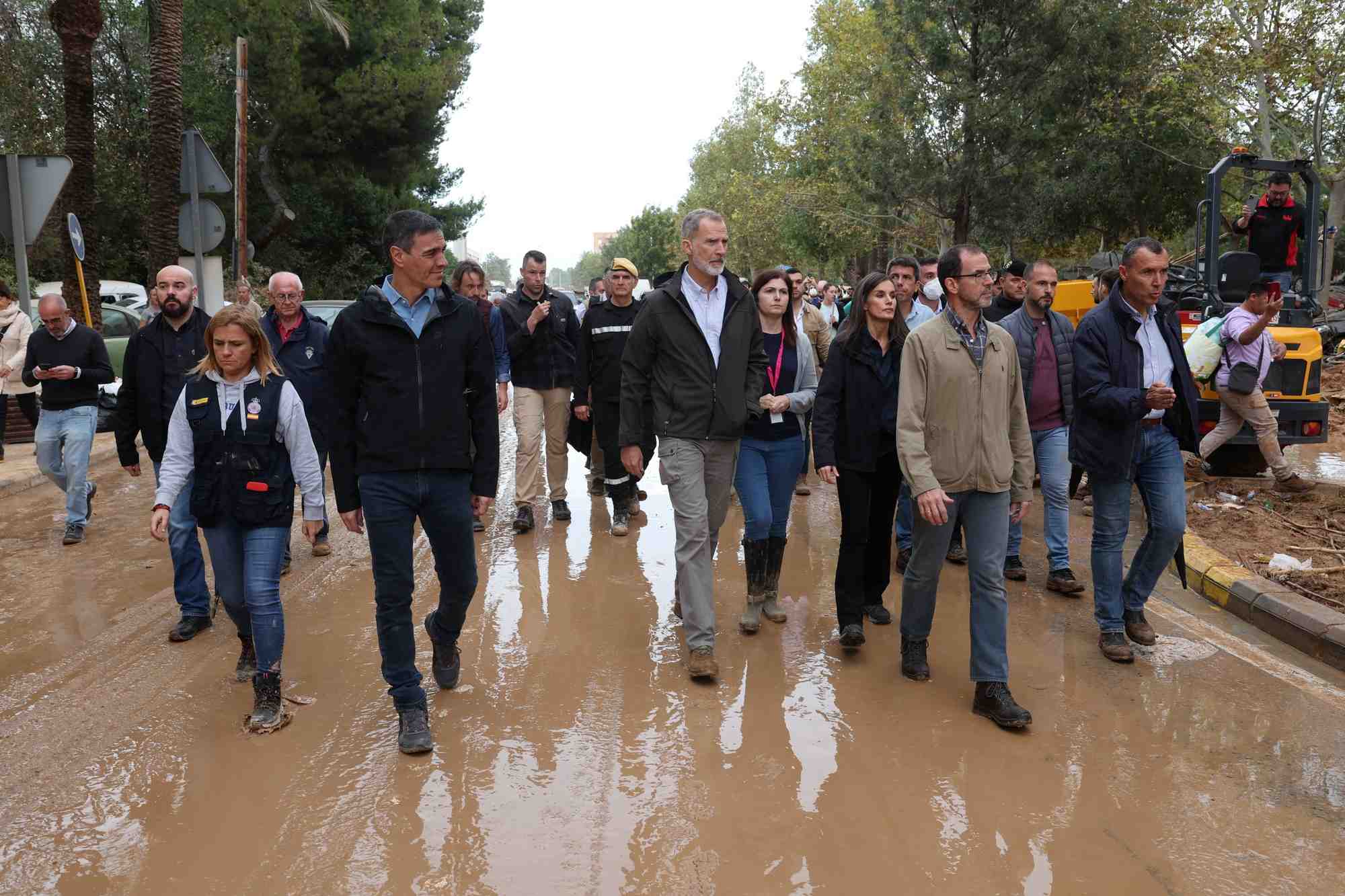 Le premier ministre espagnol pedro sanchez, le roi felipe d'espagne et la reine letizia marchent dans une rue boueuse a leur arrivee pour visiter les zones affectees par les inondations