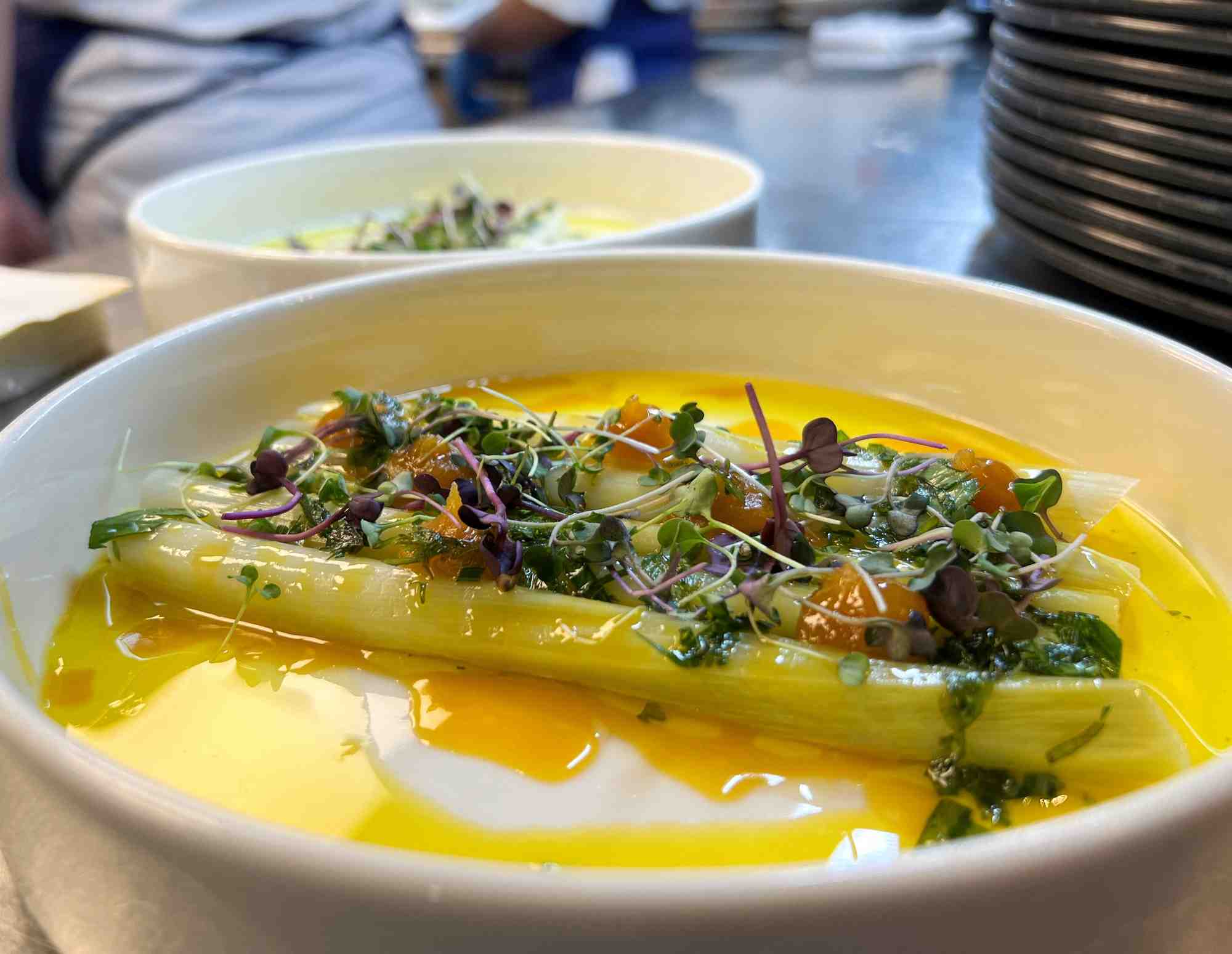 Une assiette de poireaux braises chez madame brasserie, le restaurant ouvert par thierry marx a la tour eiffel