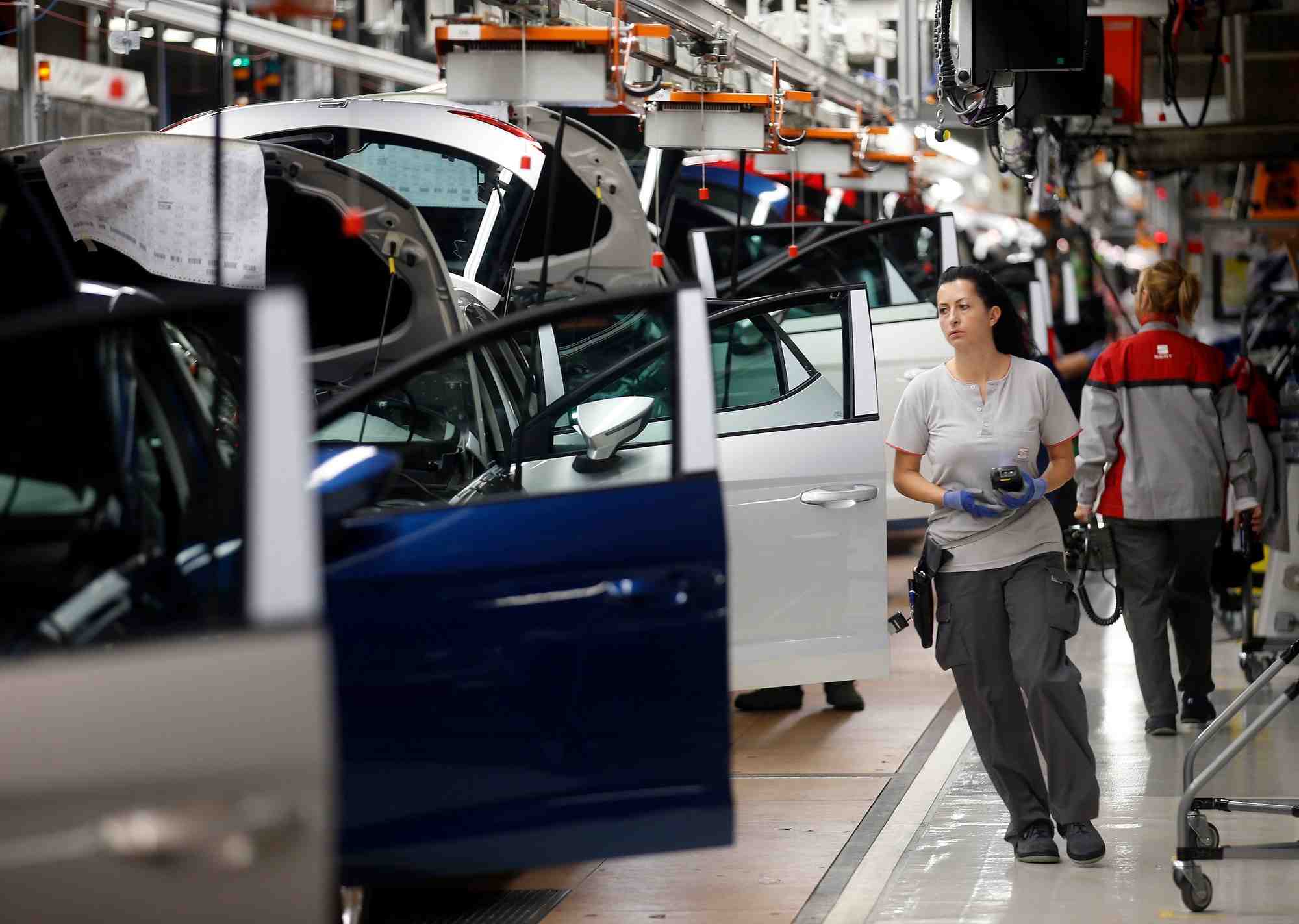 Des ouvriers assemblent des vehicules sur une chaine de montage
