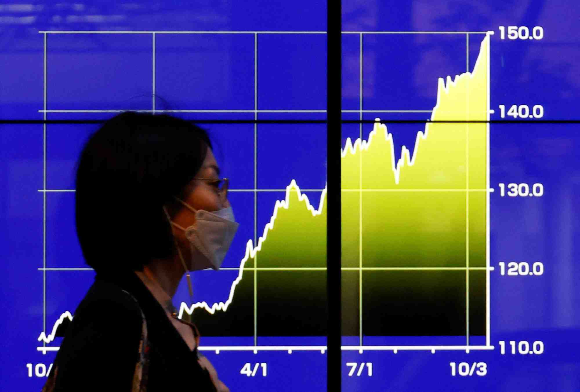 Un moniteur electrique affichant les recents du taux de change du yen japonais par rapport au dollar americain, a tokyo