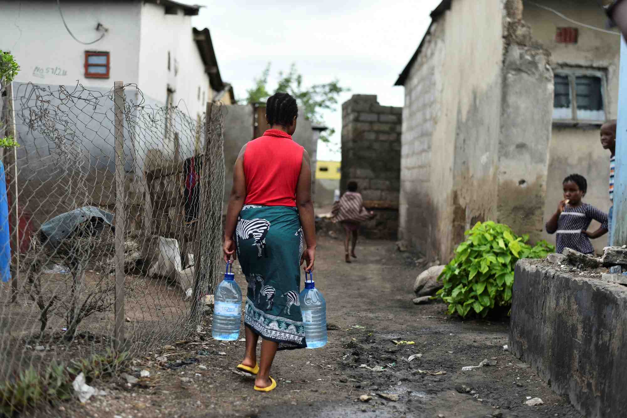 Une femme arrose dans un quartier touche par l’epidemie de cholera a lusaka, en zambie