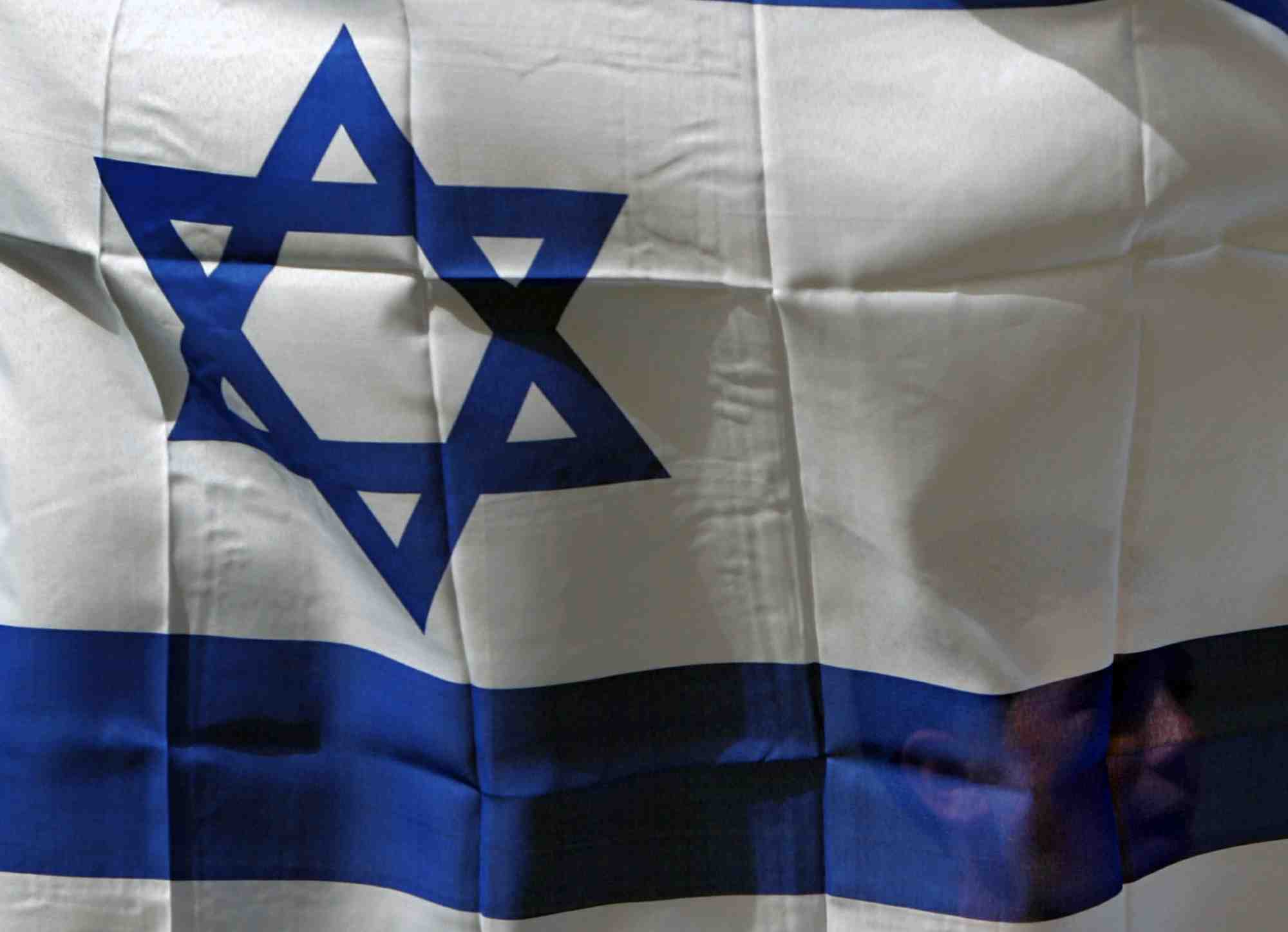 Un israelien tient le drapeau d'israel dans la ville de shfaram