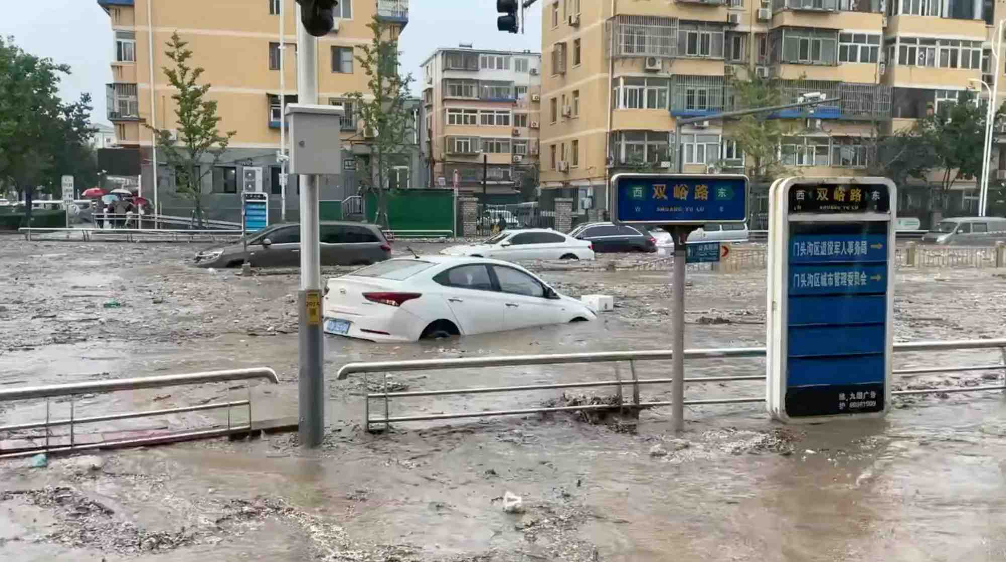 L'eau jaillit dans une rue inondee a la suite du typhon doksuri a pekin.