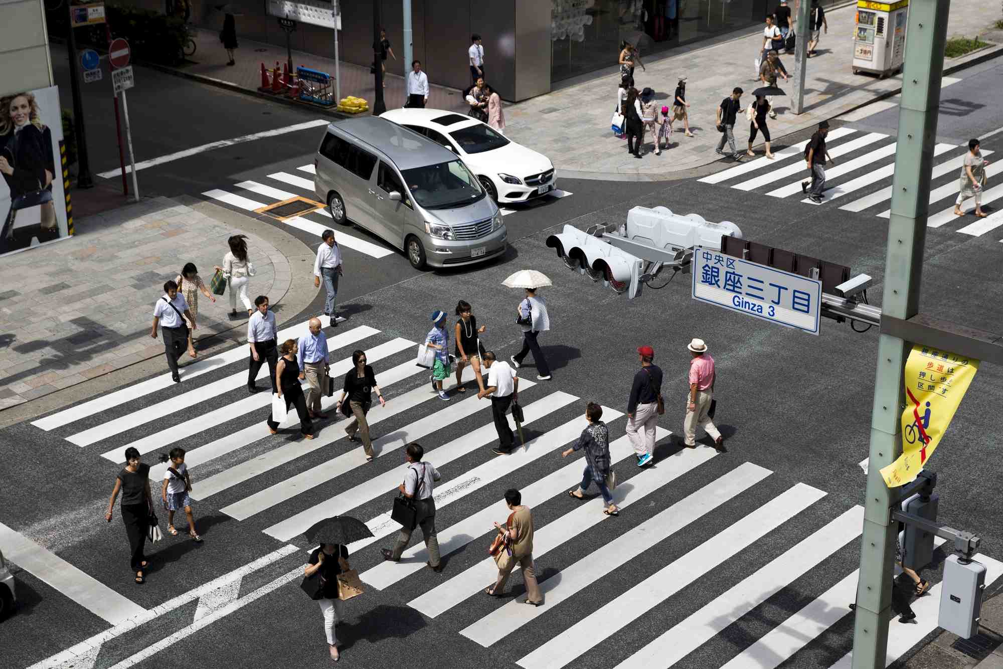 Des personnes traversent une rue dans le quartier de ginza a tokyo, au japon