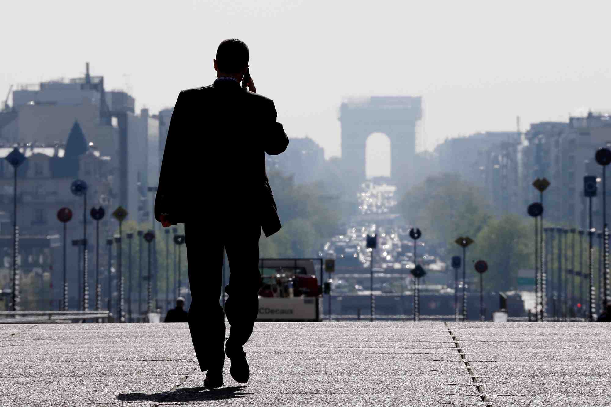 Un homme d'affaires marche sur l'esplanade de la defense