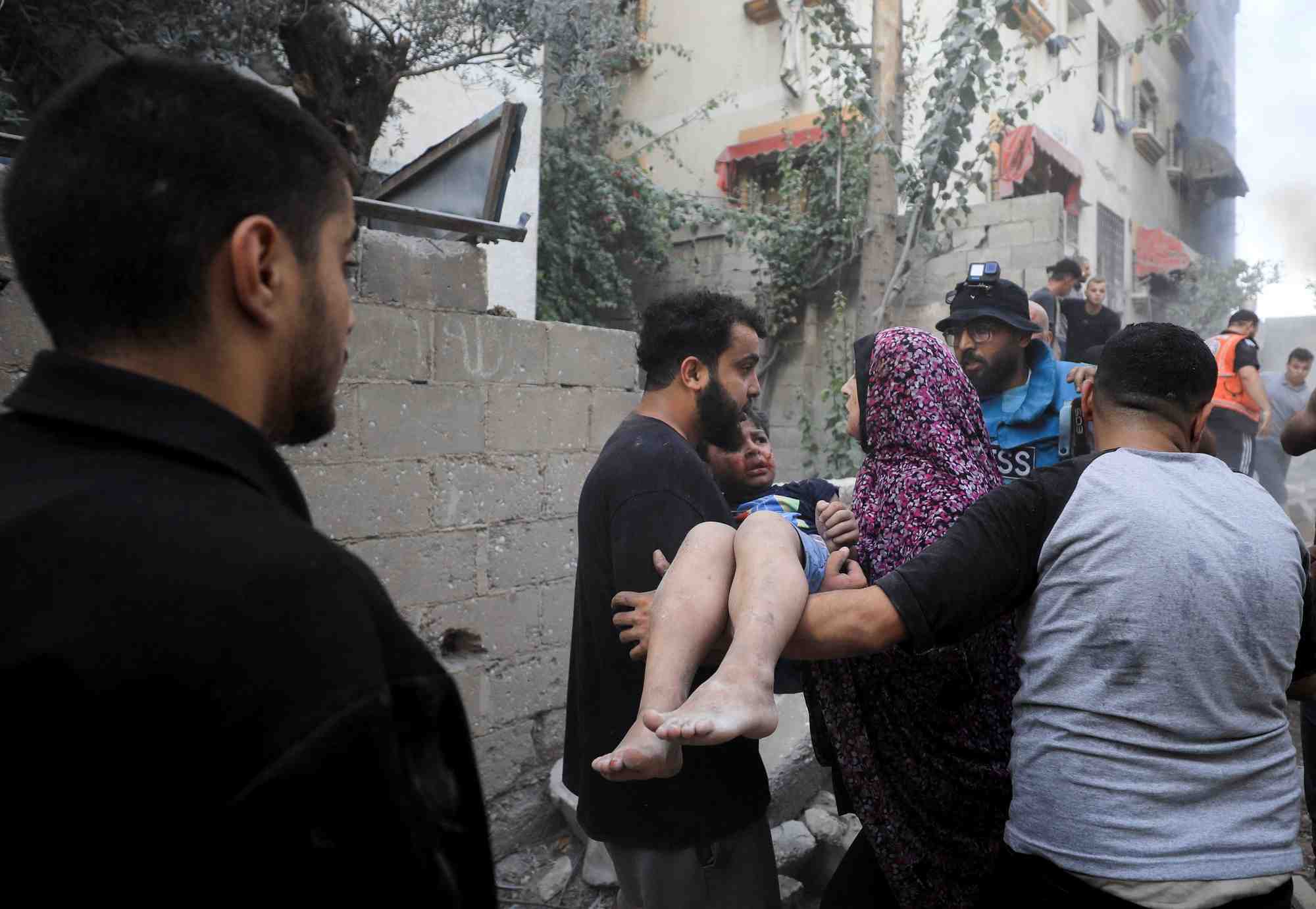 Des palestiniens tentent de sauver des personnes sur le site d'une frappe israelienne a gaza
