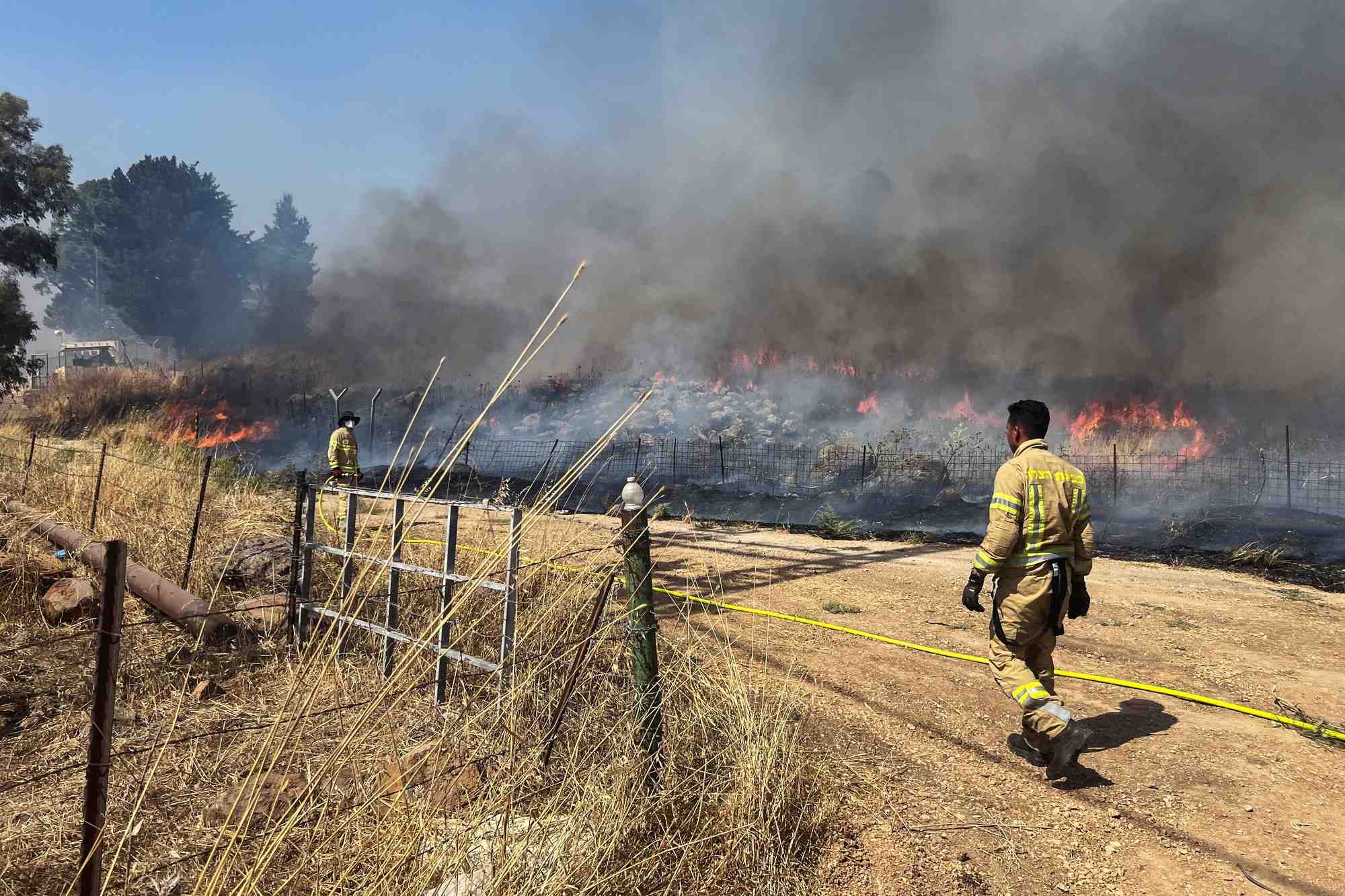 Pompiers israeliens sur le site de tirs de roquettes en provenance du liban, pres de la frontiere du cote israelien