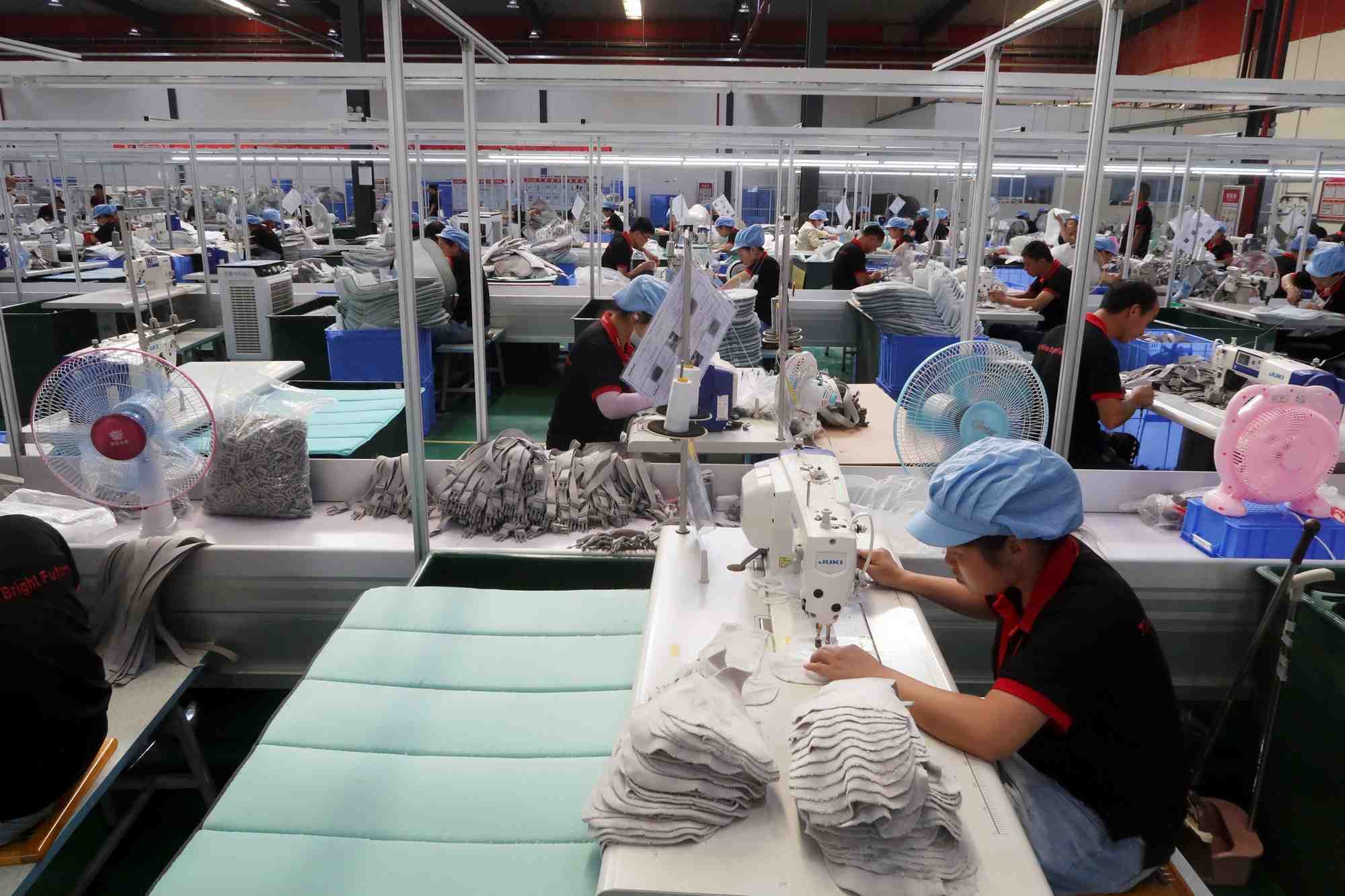 Des employes travaillent sur une chaine de production dans une usine de jiujiang, province du jiangxi, en chine