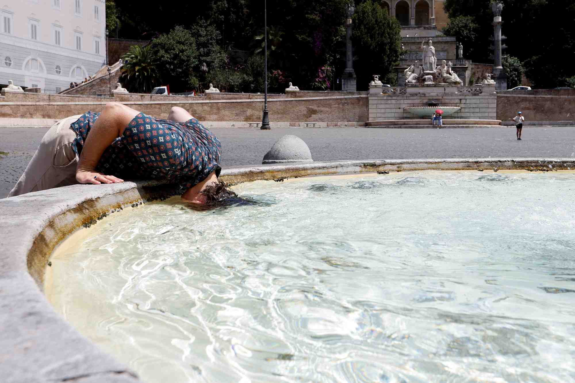 Une personne se rafraichit sur la piazza del popolo a rome