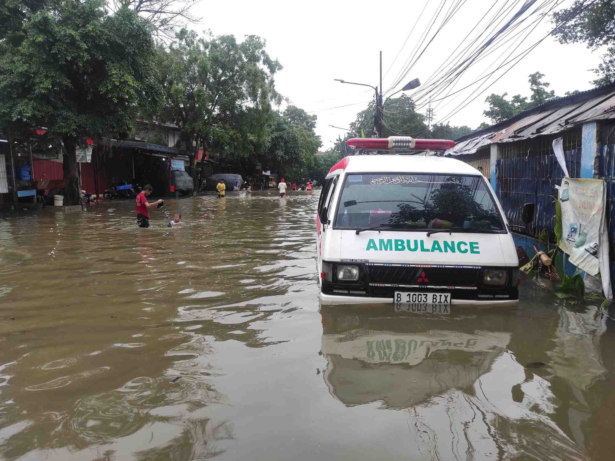 Une ambulance sur une route inondee, a jakarta