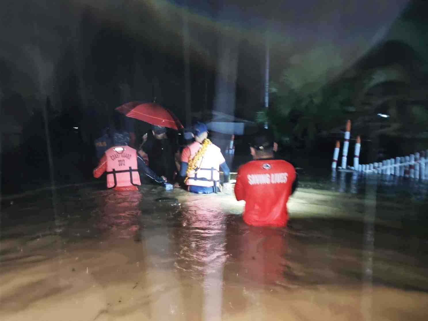 Des membres des garde-cotes philippins avancent dans une rue inondee lors d'une operation de sauvetage, a isabela