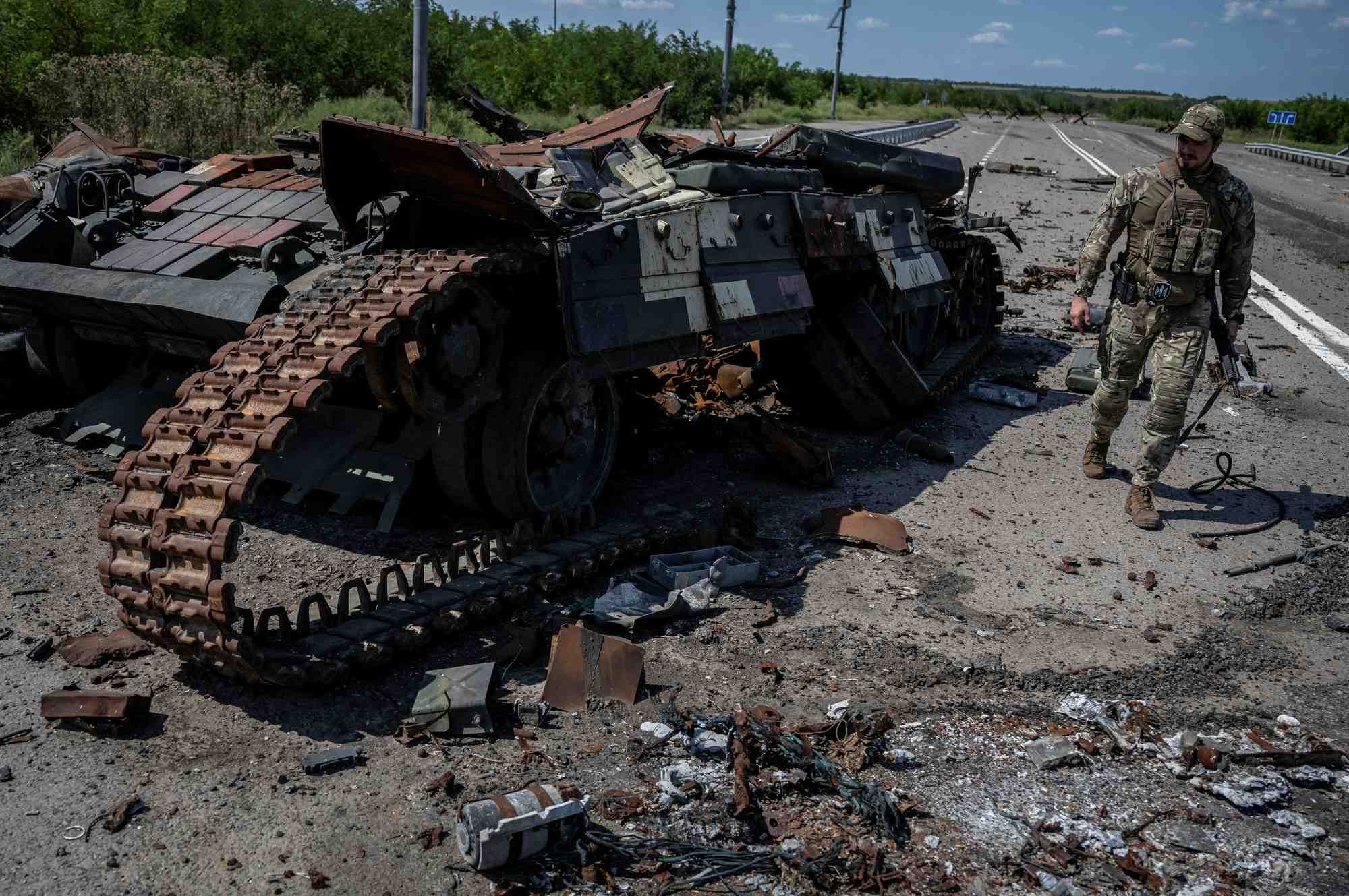 Un militaire ukrainien marche pres d’un char detruit