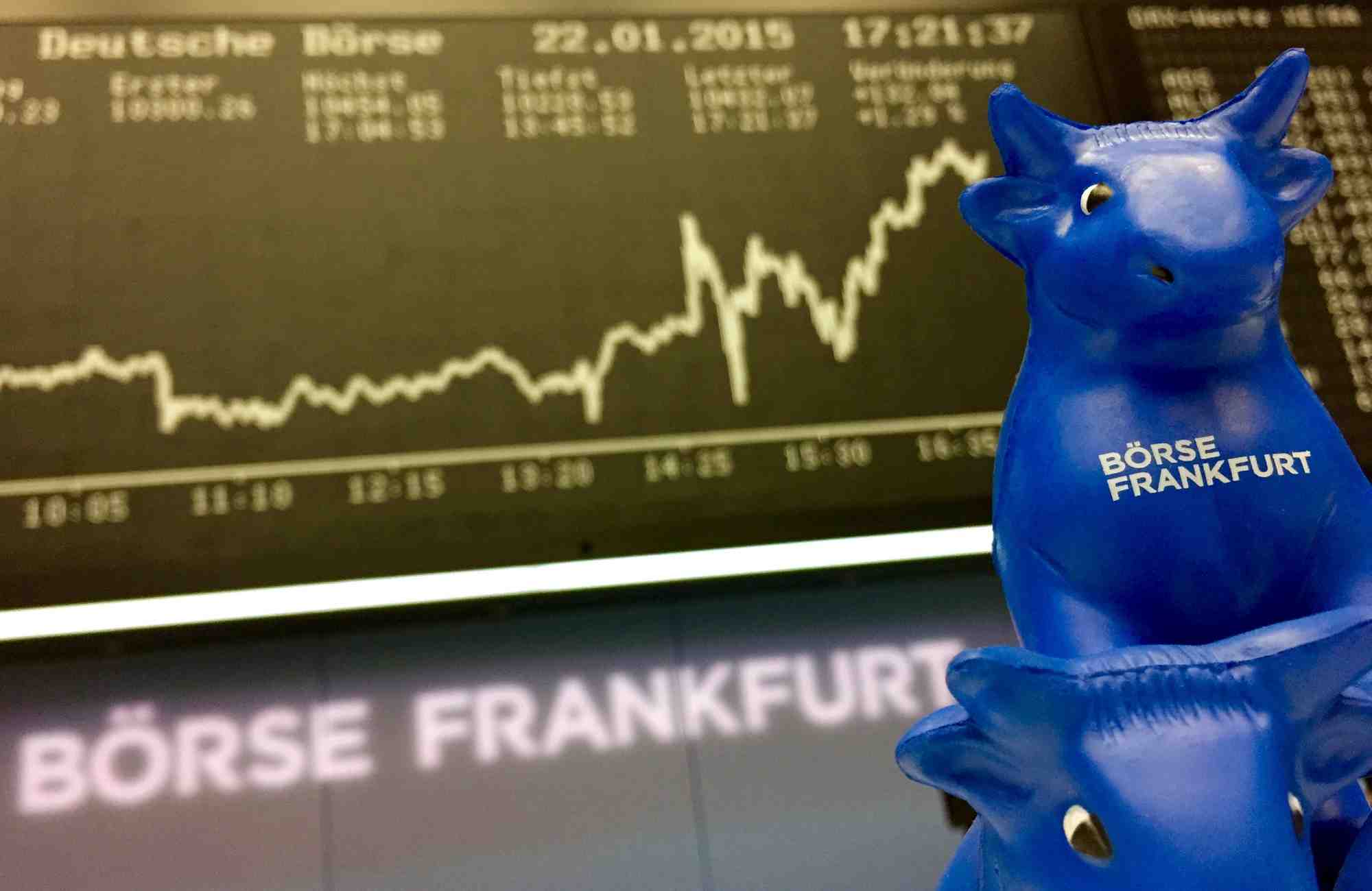 Photo d'une figurine de taureau en plastique, symbole de la bourse de francfort, devant le tableau de l'indice boursier allemand dax a la bourse de francfort