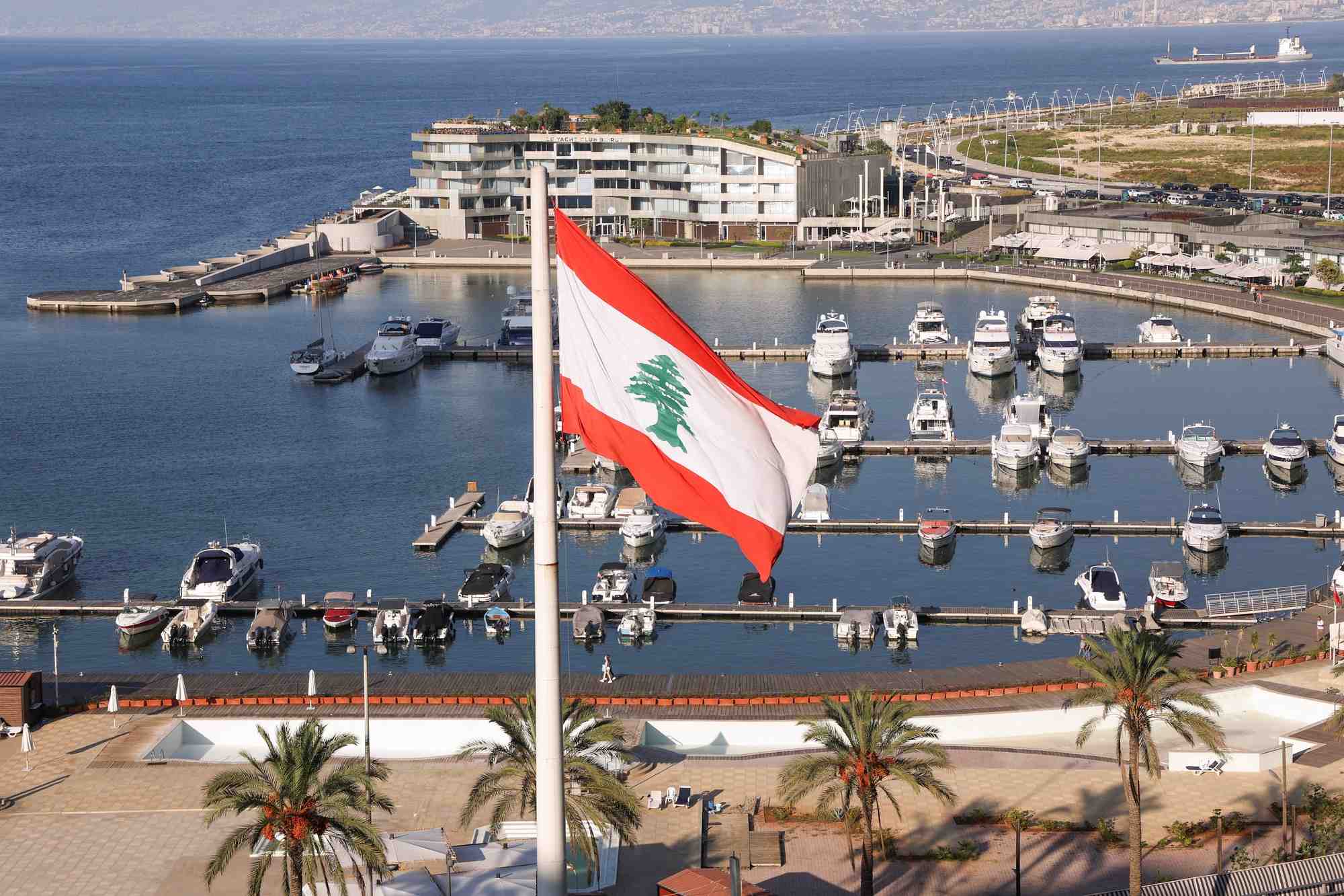Le drapeau libanais flotte pres de l'hotel phoenicia, endommage lors de l'explosion du port de beyrouth en 2020, apres sa reouverture