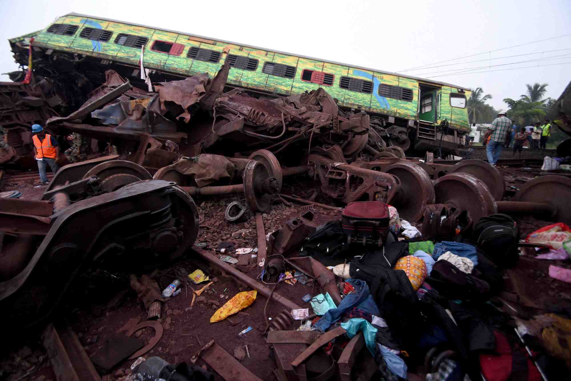 Les effets personnels des passagers a cote d'un wagon endommage apres une collision meurtriere en inde
