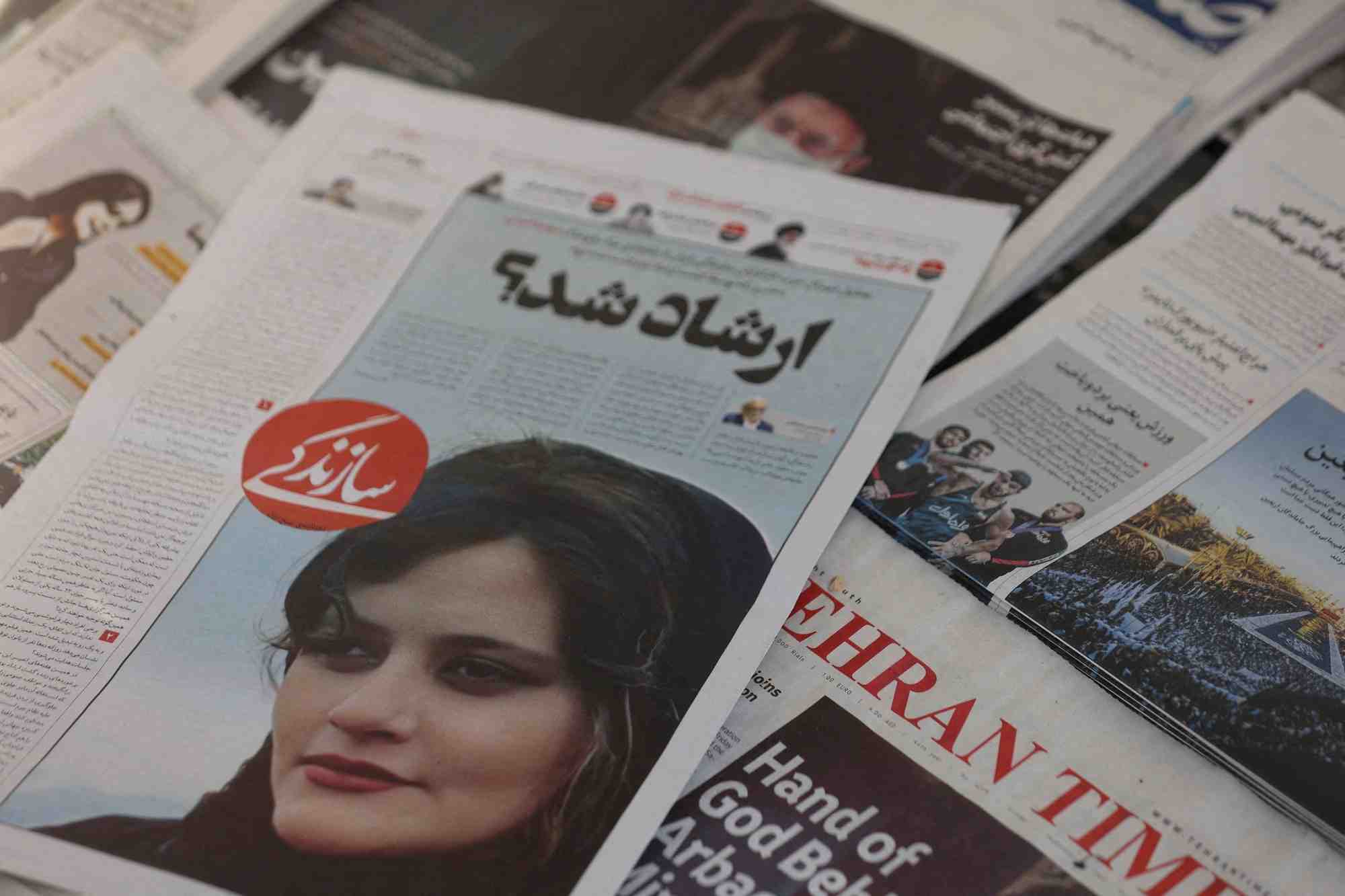 Un journal montrant une photo de mahsa amini, decedee apres avoir ete arretee par la police des moeurs iranienne, est vu a teheran