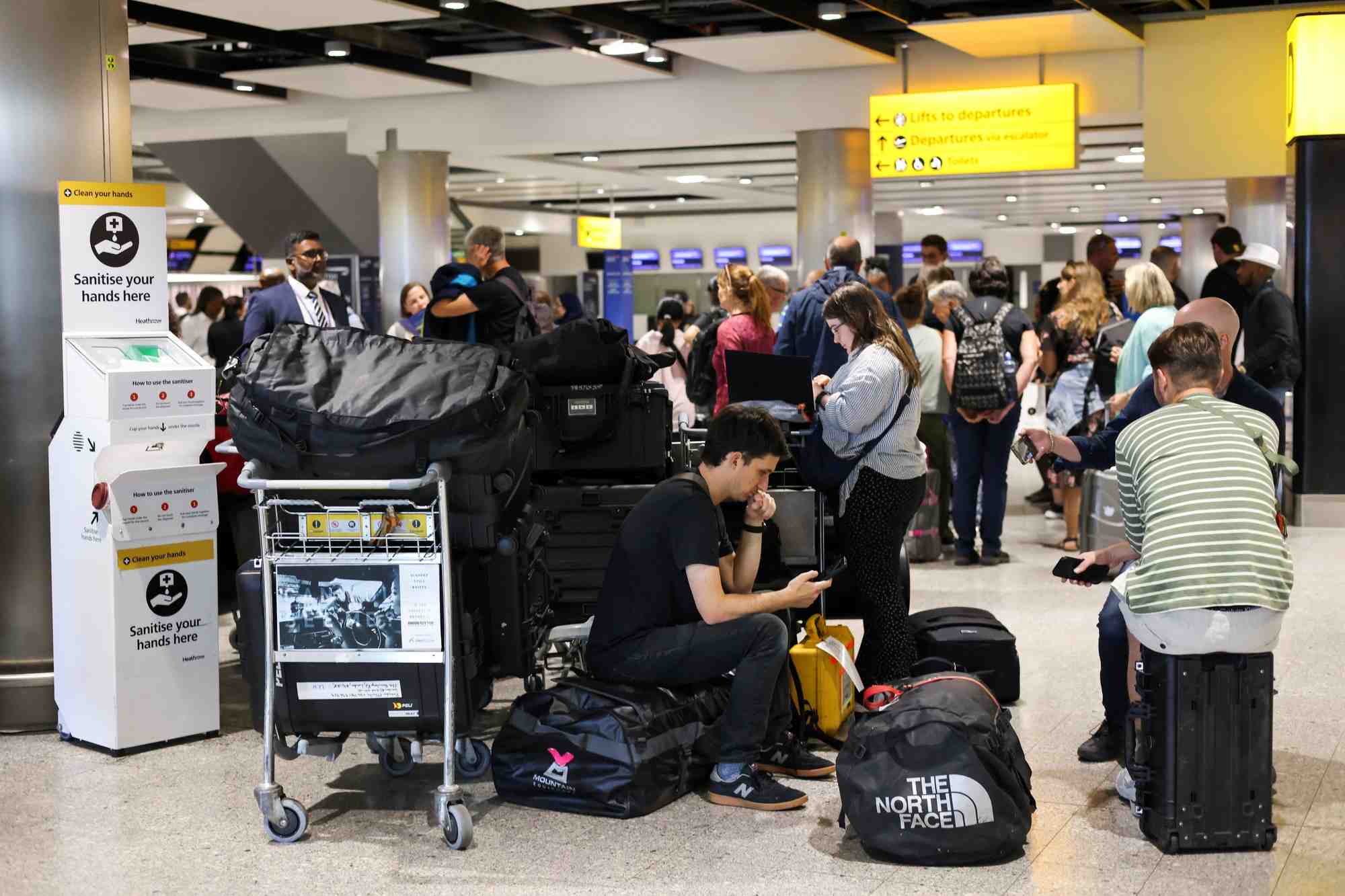 Des voyageurs attendent pres de la zone d'enregistrement de british airways a l'aeroport d'heathrow