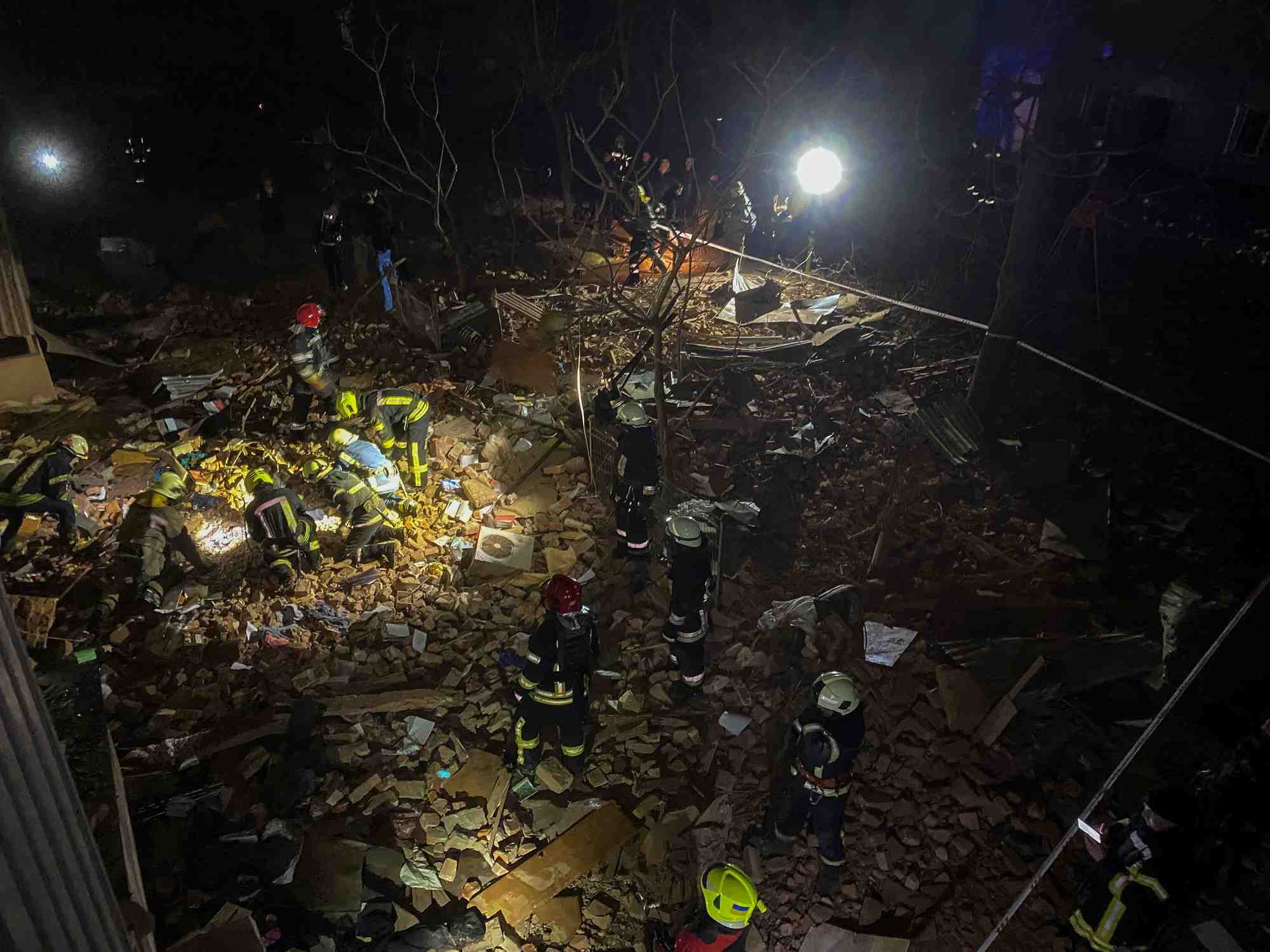 Des pompiers ukrainiens travaillent sur le site d'un immeuble d'habitation gravement endommage par un tir de missile russe a kharkov