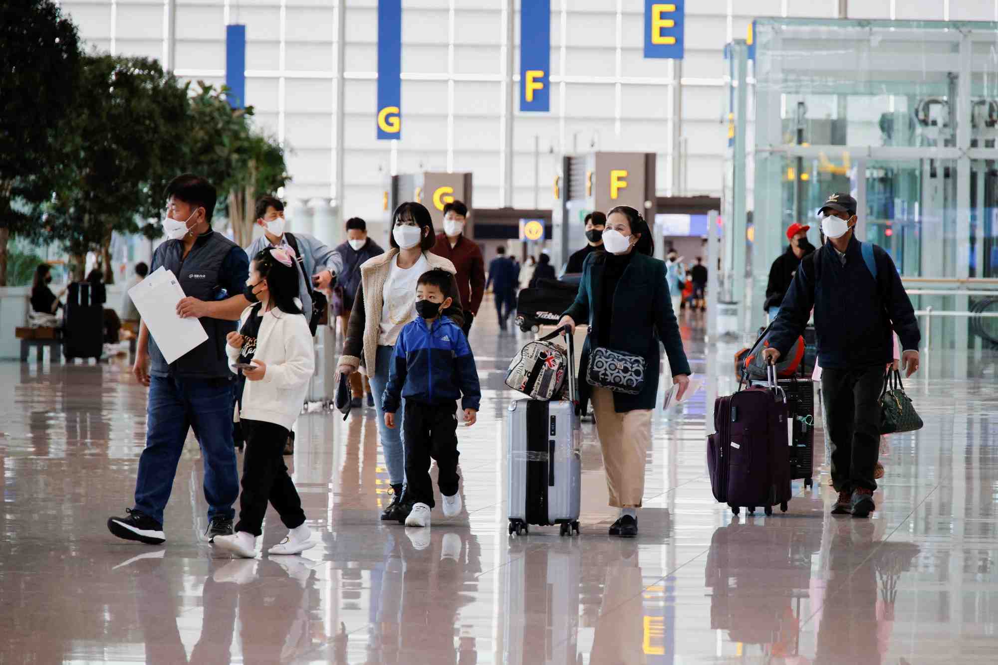 Des personnes portant des masques faciaux pour eviter de contracter la maladie du coronavirus (covid-19) marchent a l'aeroport international d'incheon, en coree du sud