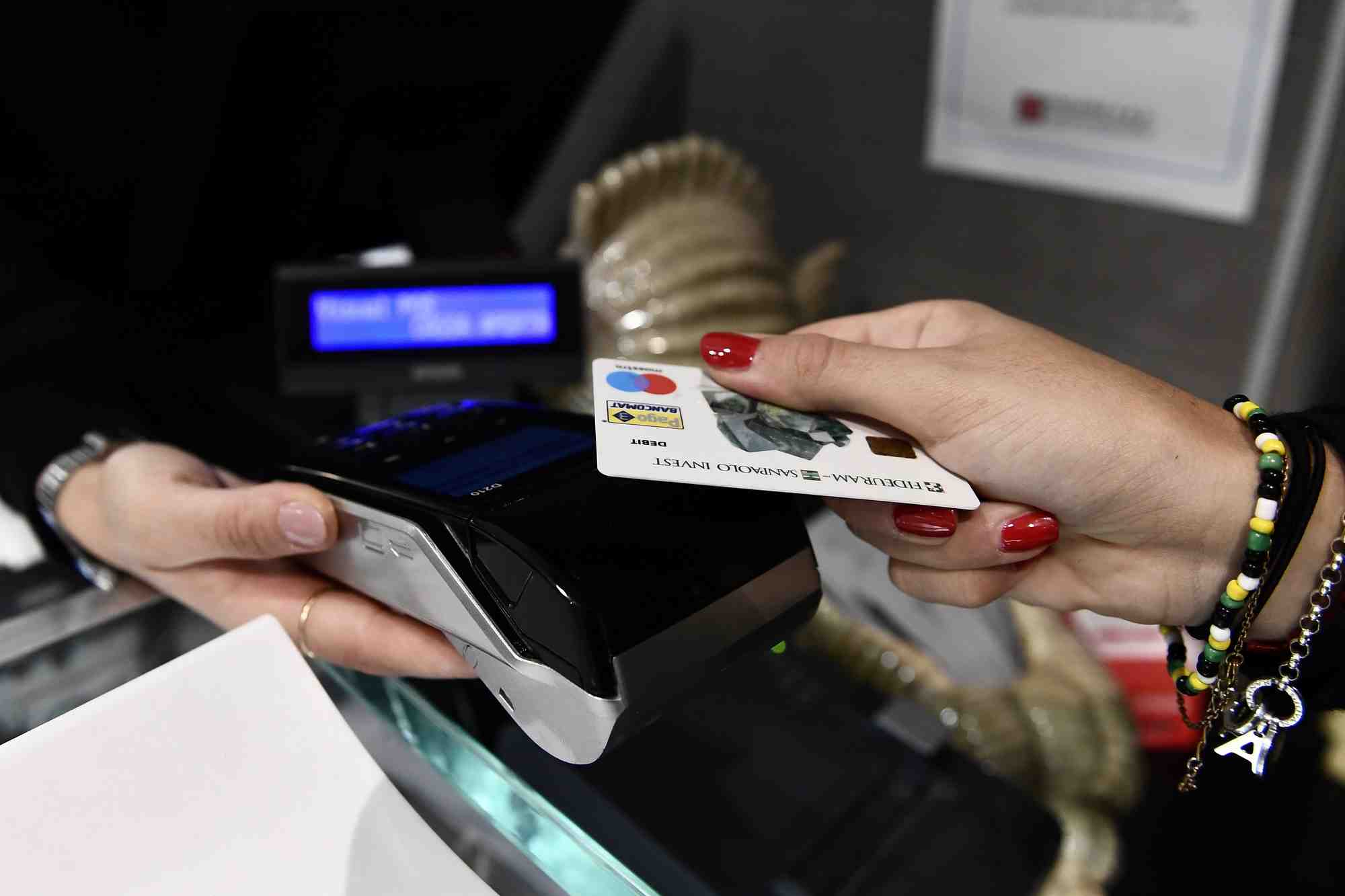Une femme utilise sa carte pour regler l'addition dans un restaurant de milan
