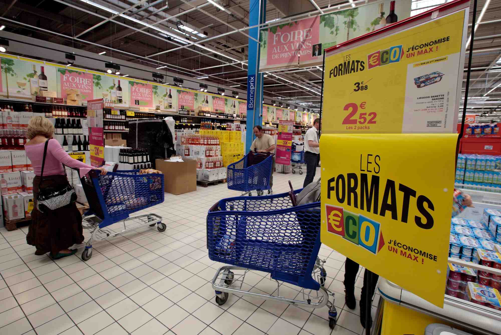 Des clients poussent des chariots a provisions dans un hypermarche carrefour a nice